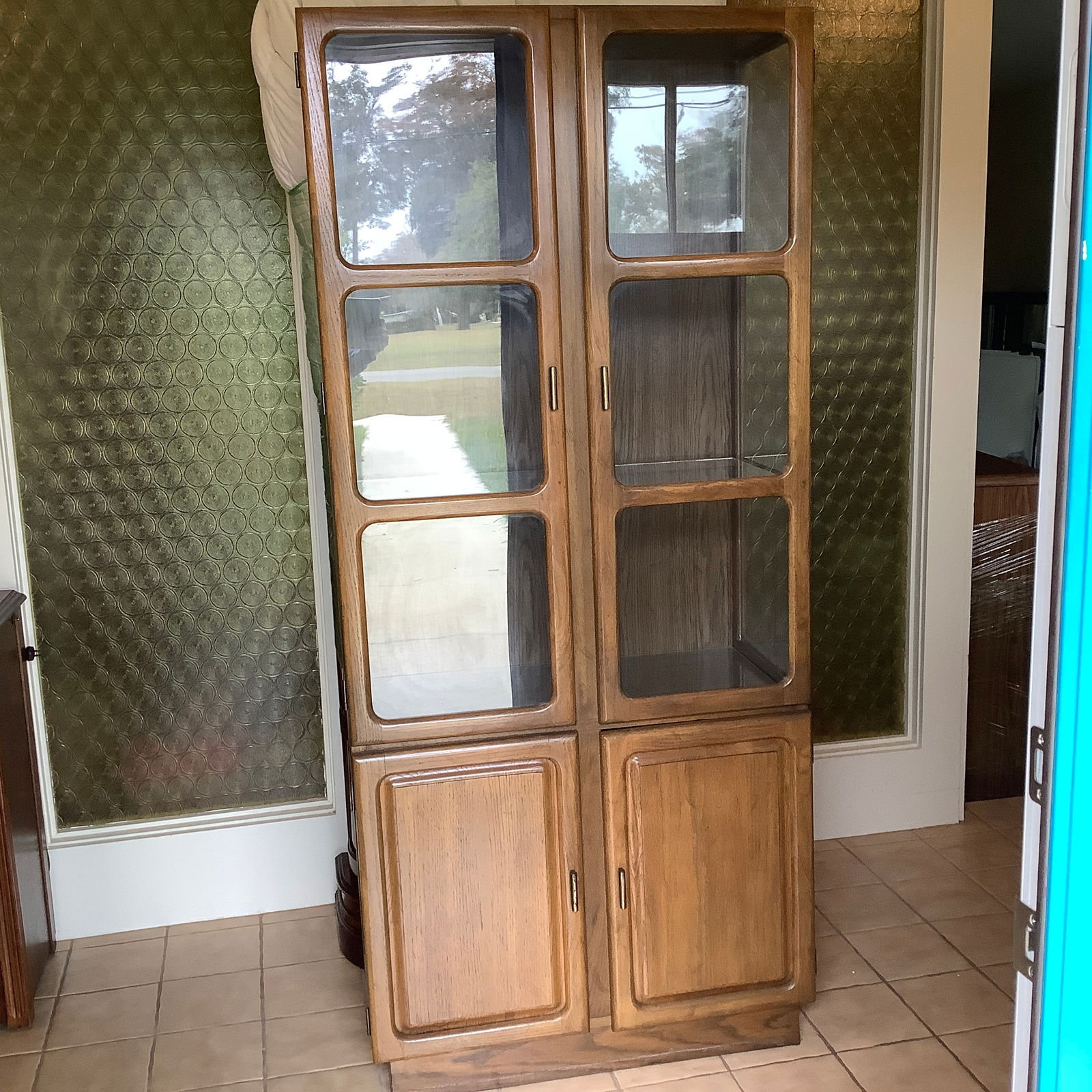 MCM China Cabinet with Lower Storage: 2 Teak Divided Glass Doors on top with solid wood doors on bottom Wood divding the panels on the front have all rounded inner corners Glass Shelves and glass sides Note: top has hole cut for adding li