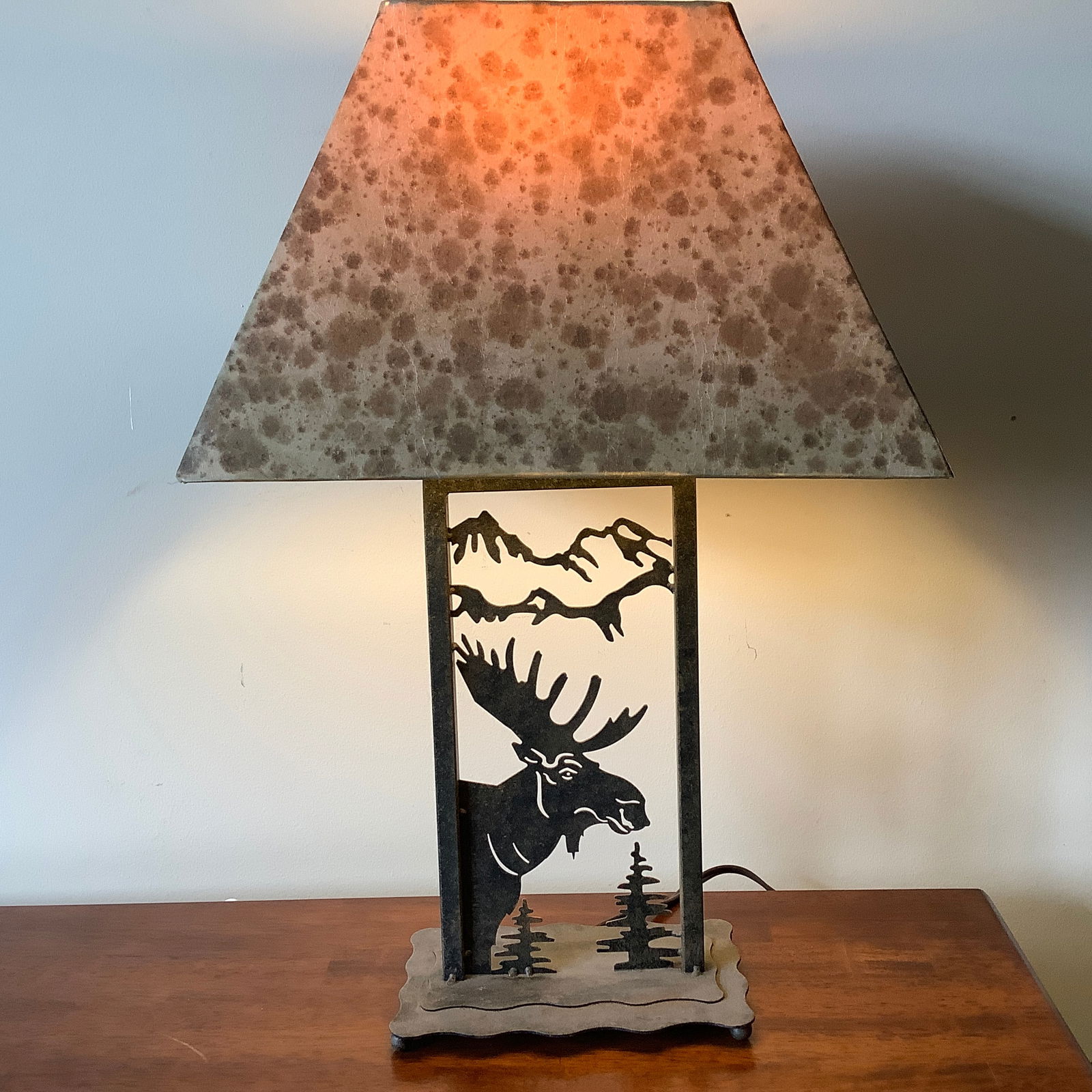 Metal Laser Cut Moose Lamp: Metal Lamp with laser cut metal design of moose, trees, and mountains Trapezoidal spotted fabric shade