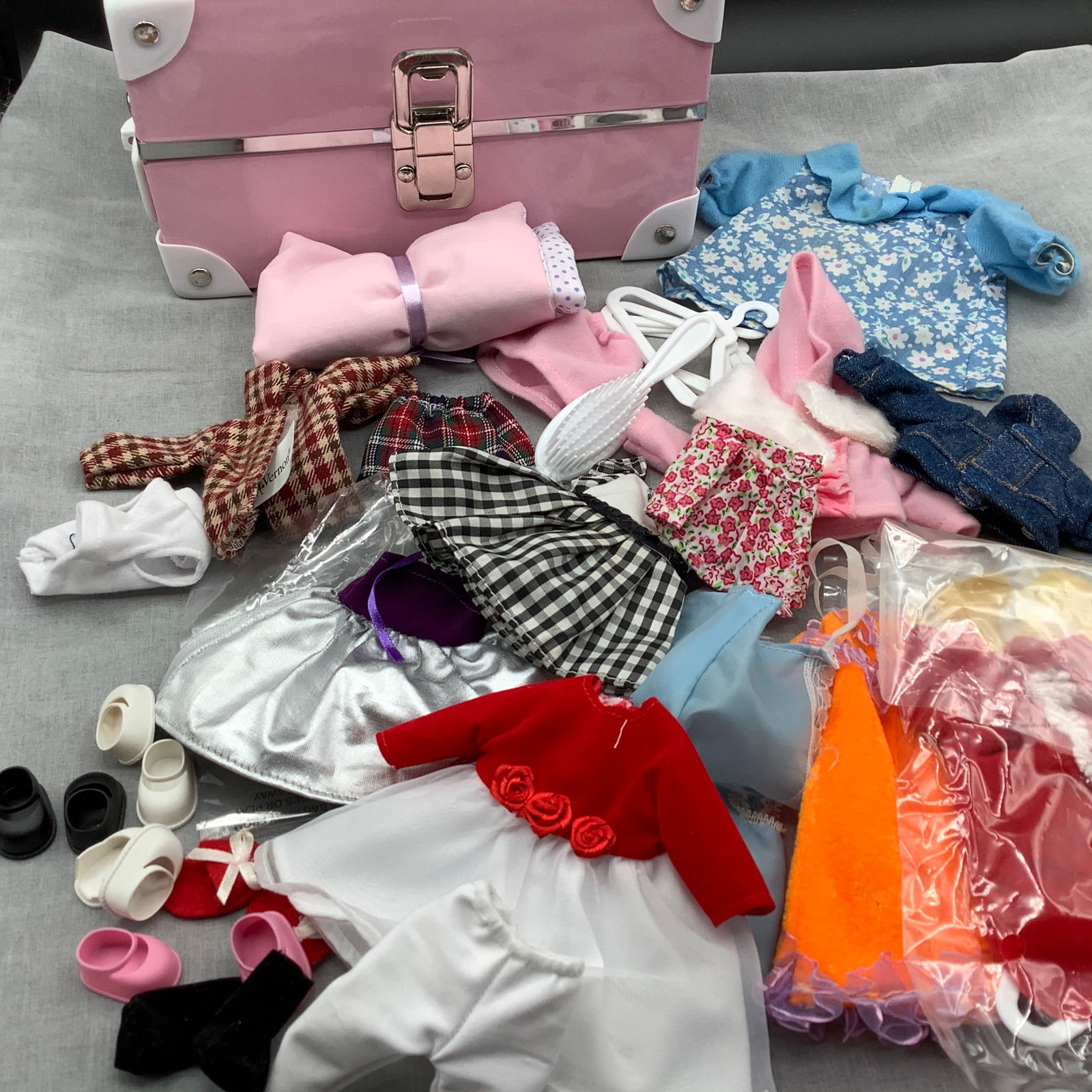 Small Box Filled With Doll Clothes: Doll clothes, shoes, hangars and storage box Note storage box has small mirror that needs reattaching