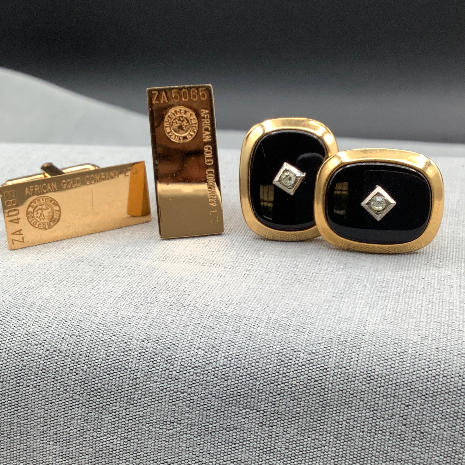 2 Pair of Cufflinks, Black/Goldtone Oval with Rhinestone and African Gold Company: Both of the African Gold Company have logo stamps along with an alphanumeric number that are both different