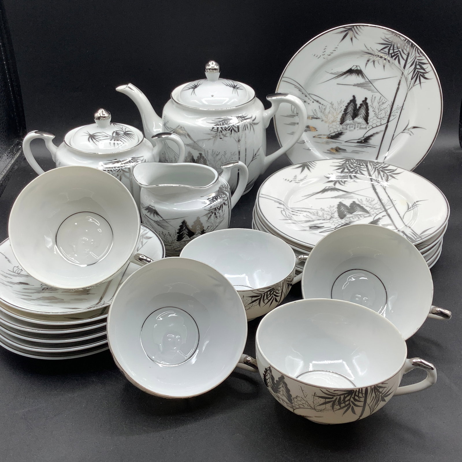 Kutani Hand Painted Bone China Tea and Dessert Set with Lithophane Geisha Faces in Teacups: 6 Dessert plates, 6 Saucers, 5 Teacups, Teapot, Creamer and Sugar Bone white china with silver bamboo and village hand painted design