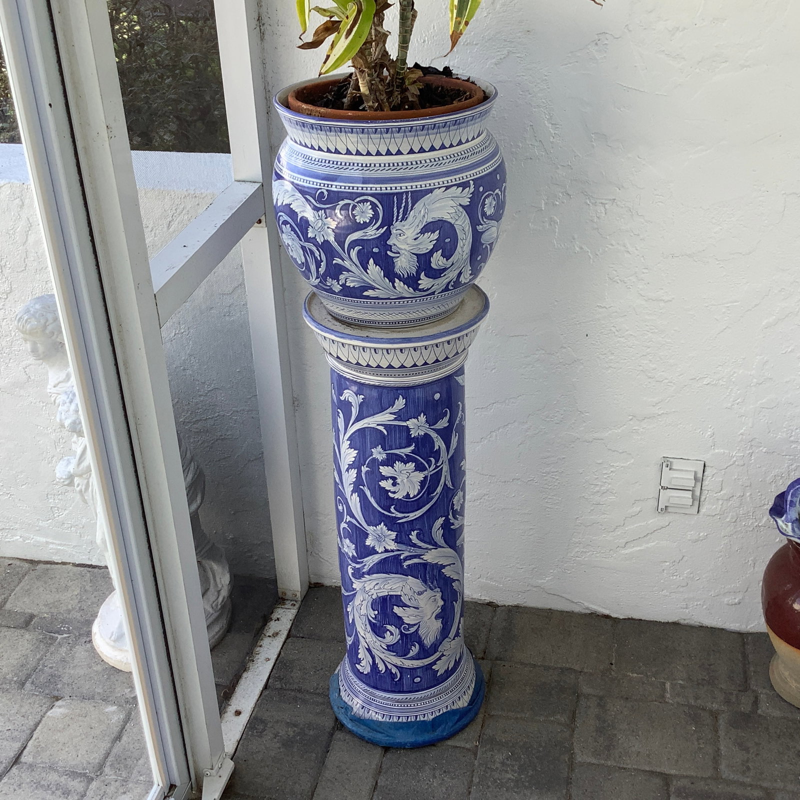 Blue and White Porcelain Planter and Jardiniere with Dracaena Plant: Plant is inside another planter. There is a row of blue tape on underside of column (It seems to have been there a long time due to tape being quite brittle) Local pick up only.