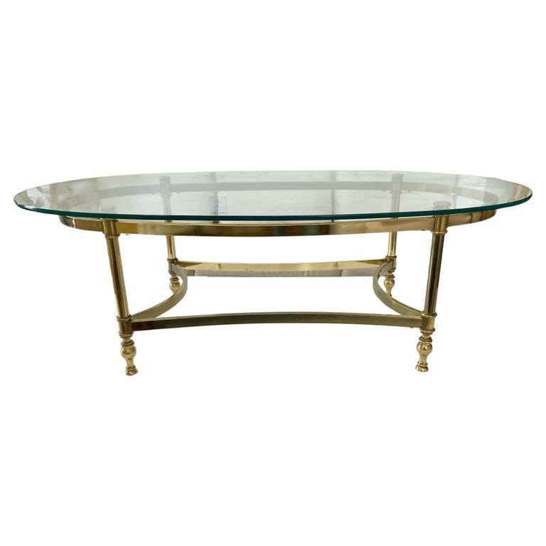 Jansen Oval Glass Top Coffee Table With Brass Metal Frame: 27"W × 49"D × 16"H 1960s Jansen oval glass top coffee table with brass metal base. Very nice classic French Jansen details. Oval Jansen tables are a nice fit to most seating arrangements. Some age o