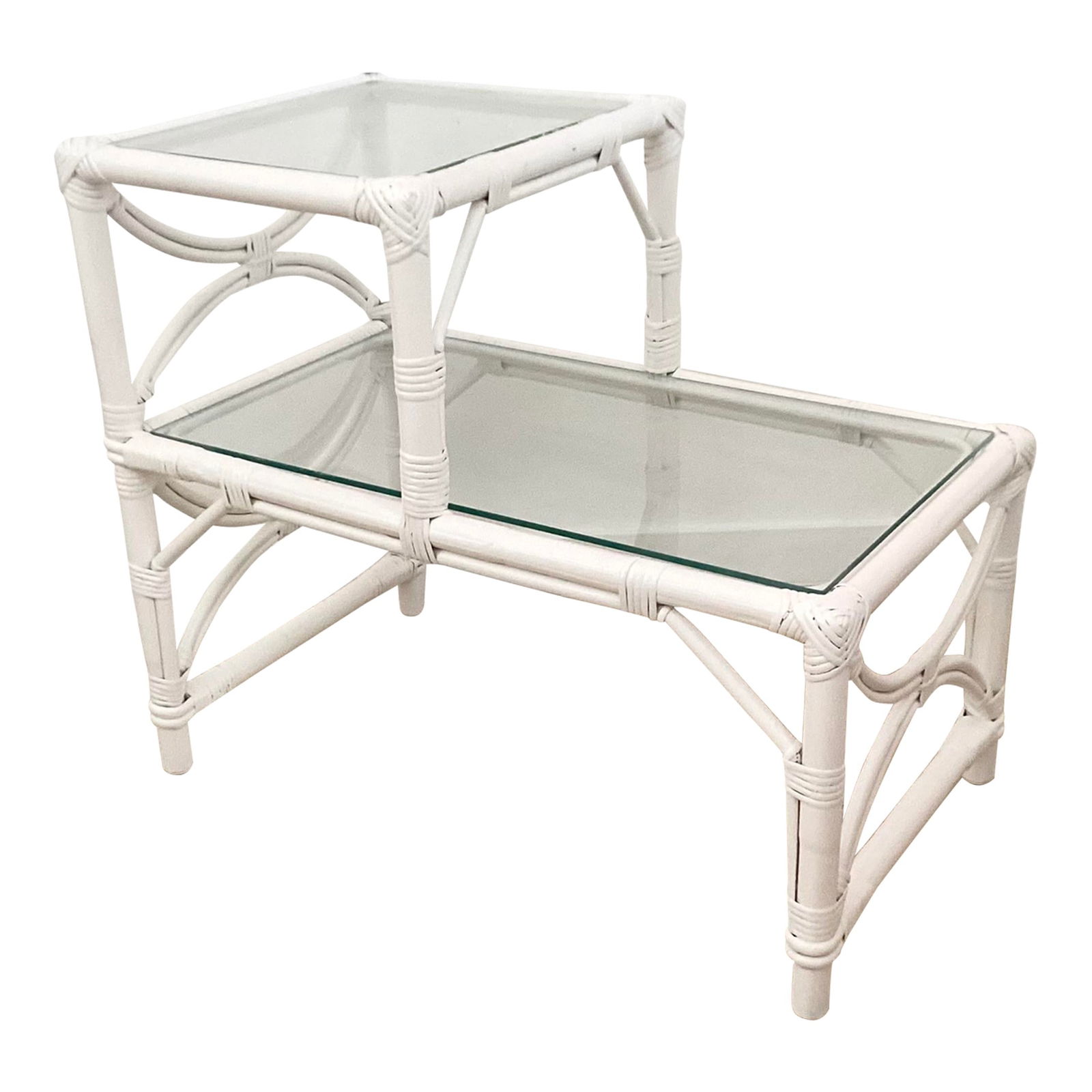 Palm Beach Ficks Reed Rattan Tier Table: 28.5"W × 17"D × 24"H Boho Chic Ficks Reed rattan tier side table lacquered in white with glass tops. Made in the 1960s. We have a similar table in our listing so collect both.