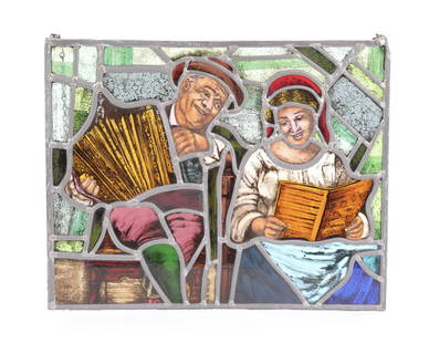 German Stained Glass Window Panel: A lovely German stained glass window panel featuring male and female musicians. There is a chain at the top for hanging. Stained glass with ink painted details and facial features. Dimensions: L: 18"