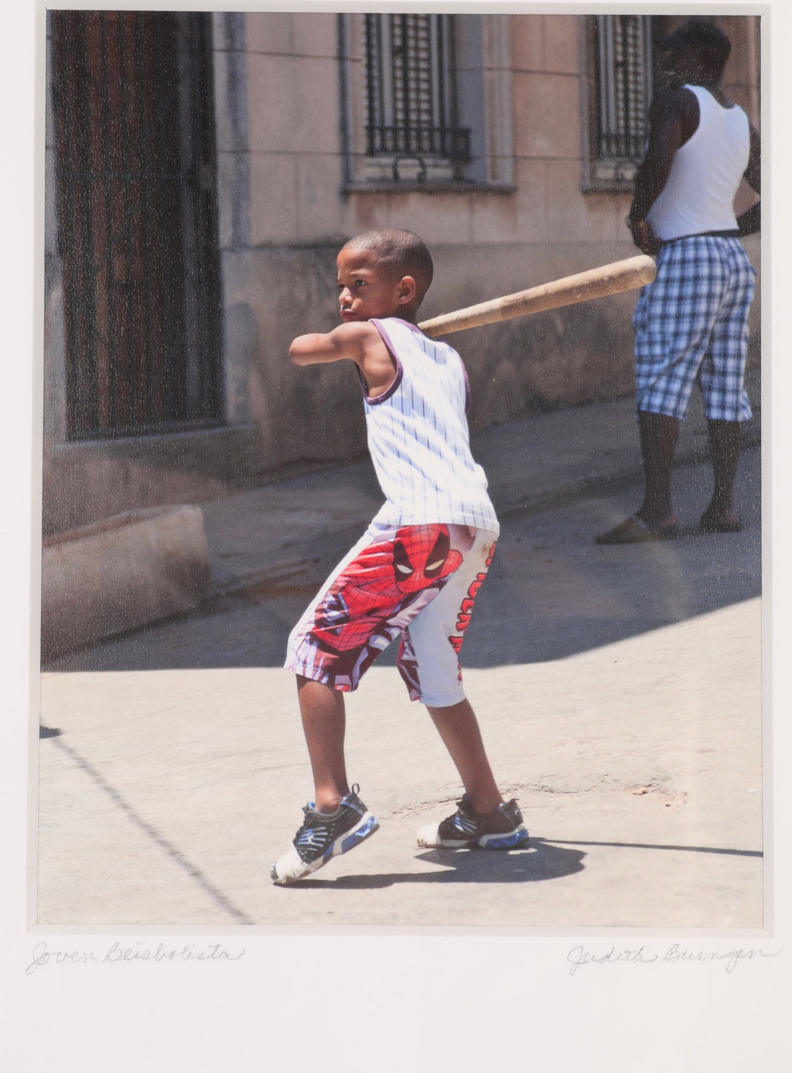 JUDITH BURNGEN Photograph "Joven Beisbolista" Havana, Cuba: A photograph of a Young Slugger in Havana, Cuba by artist Judith Burngen. "Joven Beisbolista" titled, and signed lower recto with artist gallery label and info on verso. Nicely framed under glass. Dim
