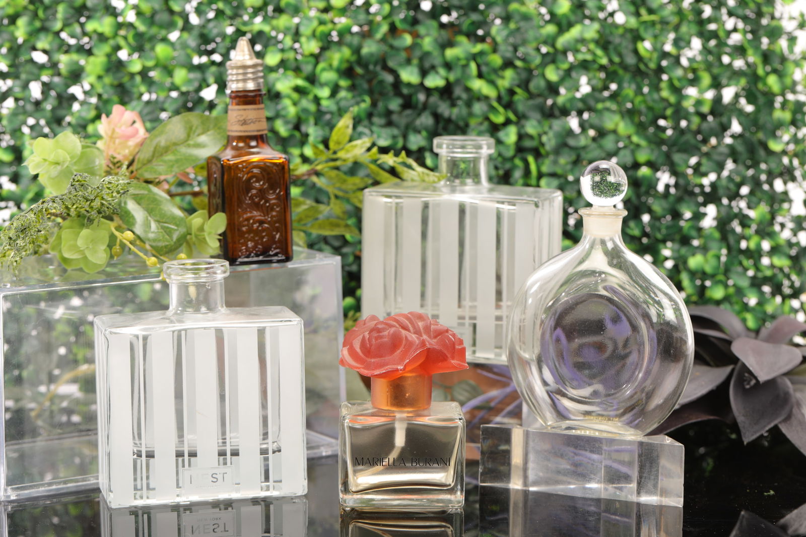 5 VTG PERFUME BOTTLES NEST GUERLAIN MARIELLA BURANI STETSON: A lot of five vintage perfume bottles. Most are empty. 1. 2x NEST NEW YORK crystal bottles: 4.25" x 3.75" 2. Mariella Burani with flower top: 3" x 2.5" 3. Brown Stetson bottle: 4" x 1.5" 4. Guerlain w