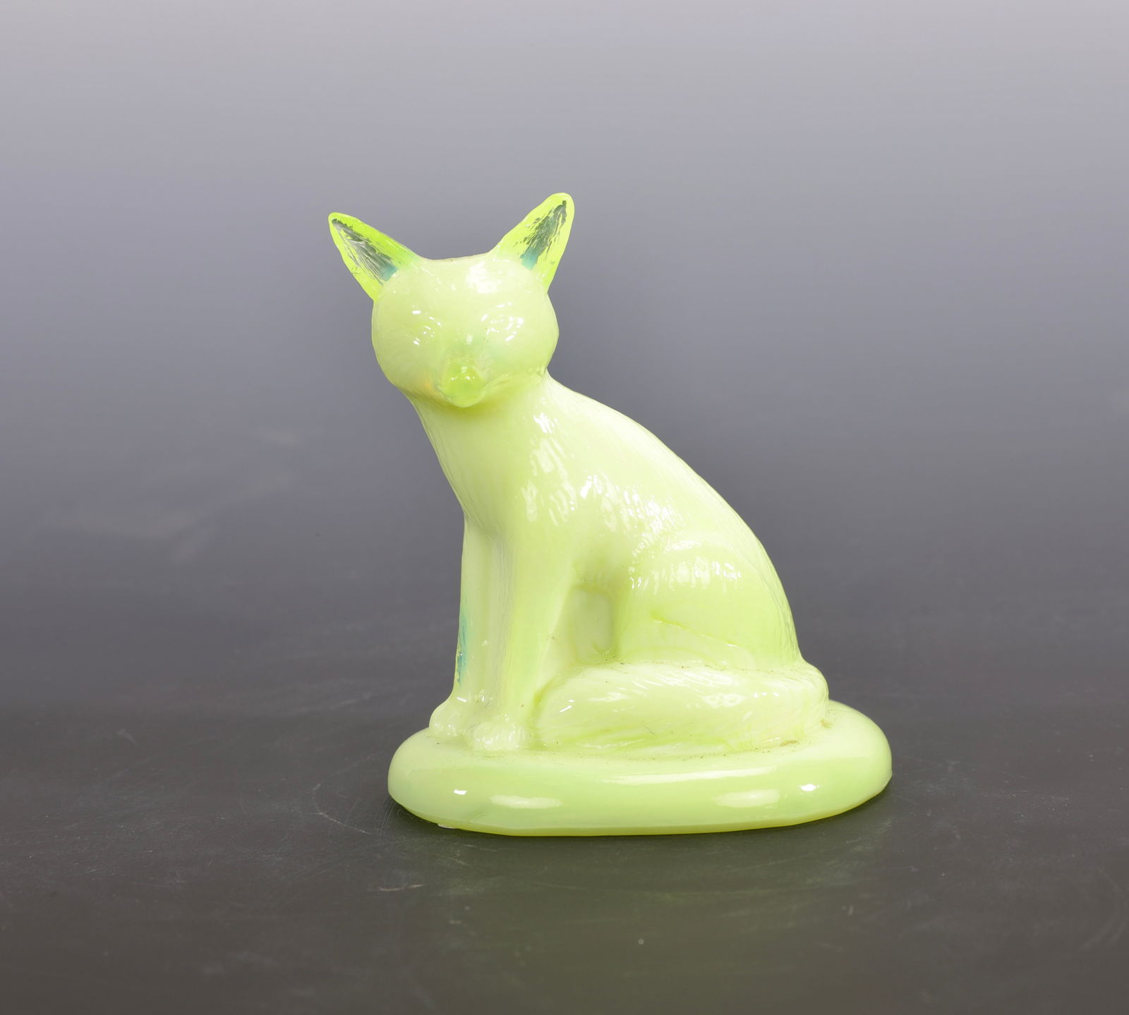 BOYD URANIUM CUSTARD GLASS GLASS FOX FIGURINE PAPERWEIGHT: A uranium glass cat or fox figurine or paperweight. UV reactive - glows under a black light. Marked with B for Boyd's Glass Measures: 3" H x 2.5" W INV #- 10 Yellow