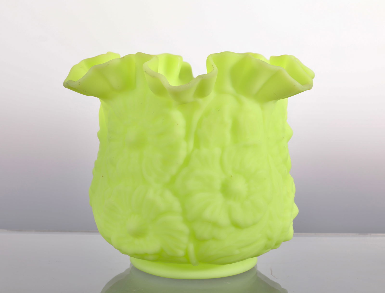 FENTON URANIUM CUSTARD GLASS VASE POPPY PATTERN: A fine Fenton uranium custard glass vase. It has a ruffled edge and is made of uranium glass, which causes it to glow under a blacklight. Key Lime or Lime Satin color. Measures: 6"H x 5.5" Diam INV#-