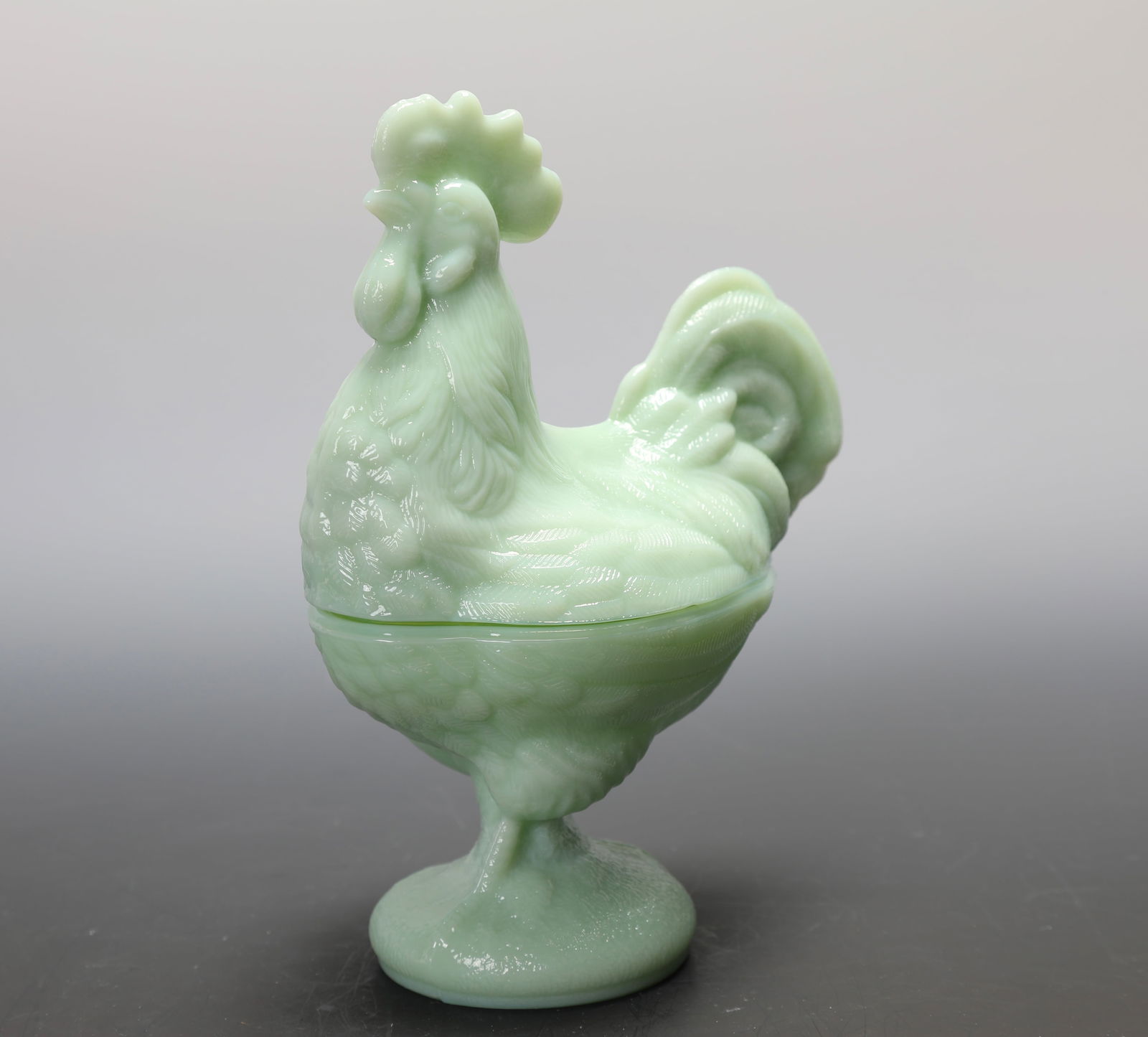 GREEN JADEITE GLASS ROOSTER FORM COVERED DISH: A green Jadeite glass rooster form covered dish. Age unknown. I believe this was made by Mosser or LE Smith. Measures: 8.5" H x 7" x 4" INV#-