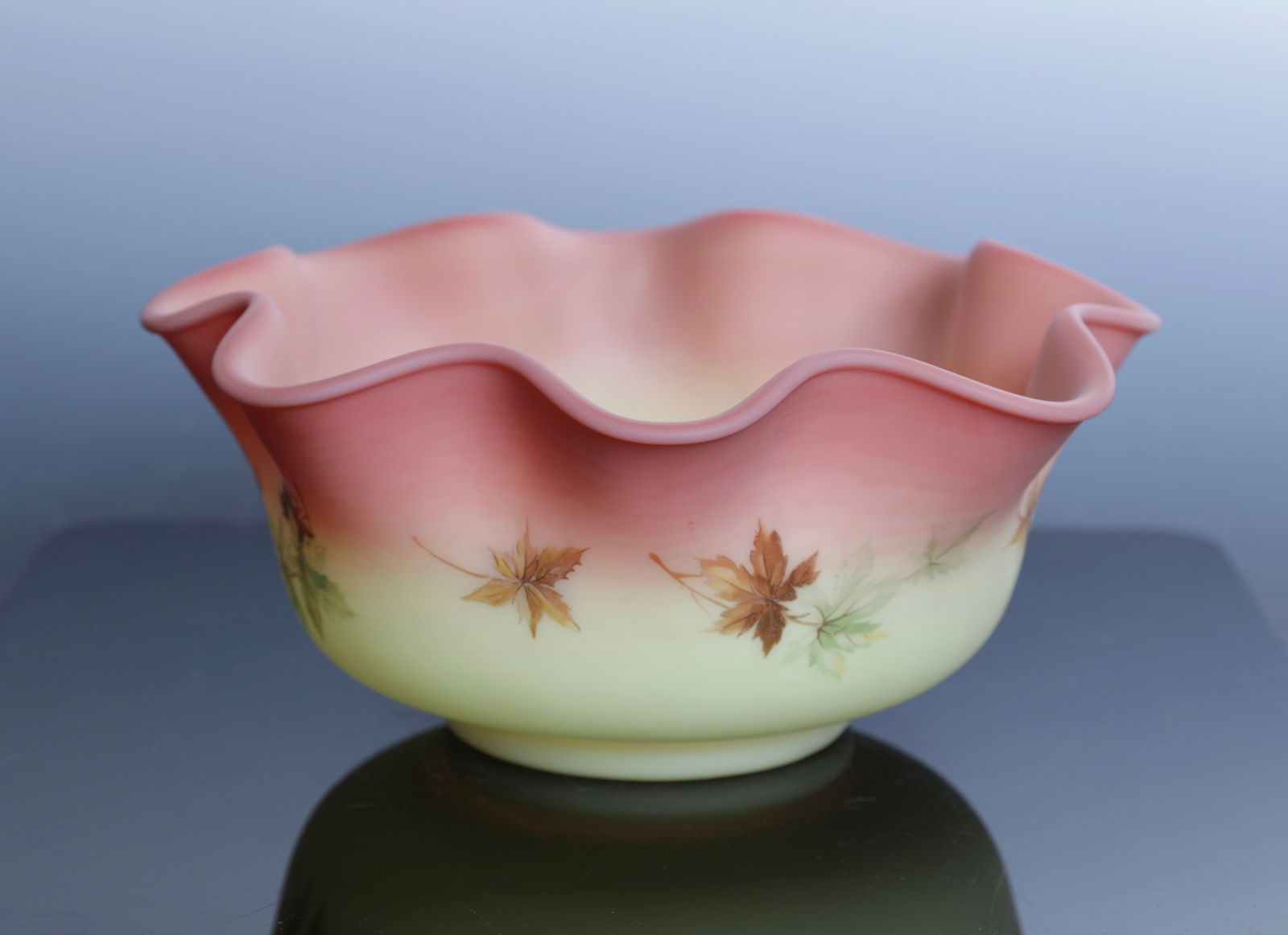 FENTON BURMESE GLASS HANDPAINTED BOWL UV REACTIVE: A lovely Fenton Burmese glass bowl. It features a ruffled rim and a handpainted maple leaf design. It is UV reactive and glows under a black light.Measures: 4"H x 8.5"Diam INV#- 