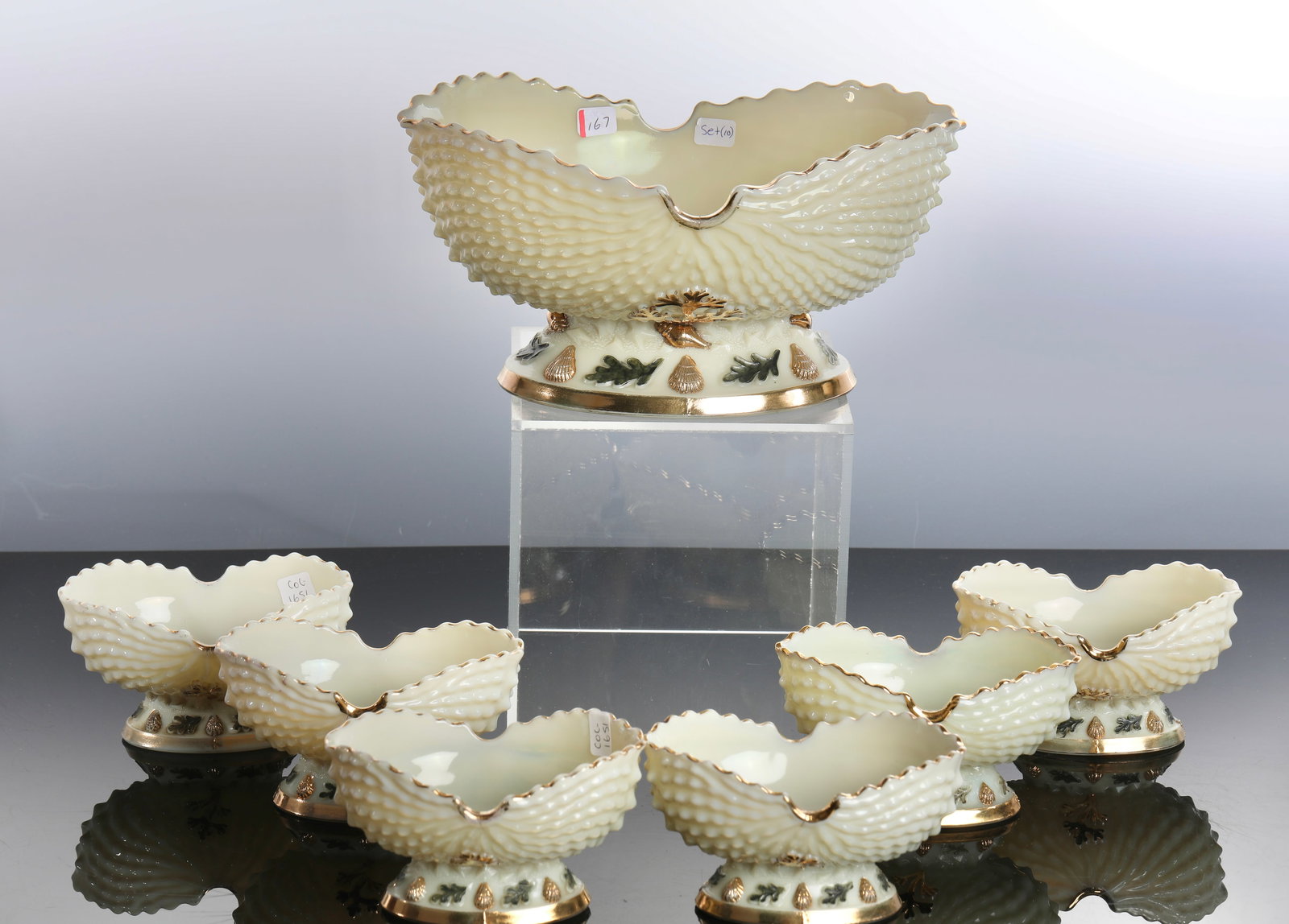 NORTHWOOD ARGONAUT SHELL CUSTARD GLASS BERRY BOWL 7 PC SET URANIUM: A Northwood Argonaut shell custard glass berry bowl 7 piece set. It dates to the early 1900s and the pieces feature a nature/ocean theme with a textured shell shape. They are decorated with hand-paint