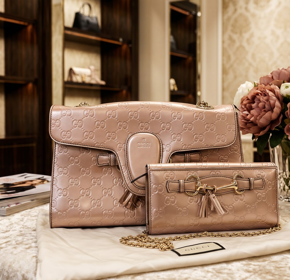 GUCCI EMILY CHAIN SHOULDER BAG & CONTINENTAL CHAIN WALLET: This matching luxury set features the Gucci Emily Chain Shoulder Bag paired with its coordinating Emily Continental Chain Wallet. Both pieces are rendered in the house's eye-catching metallic rose gol