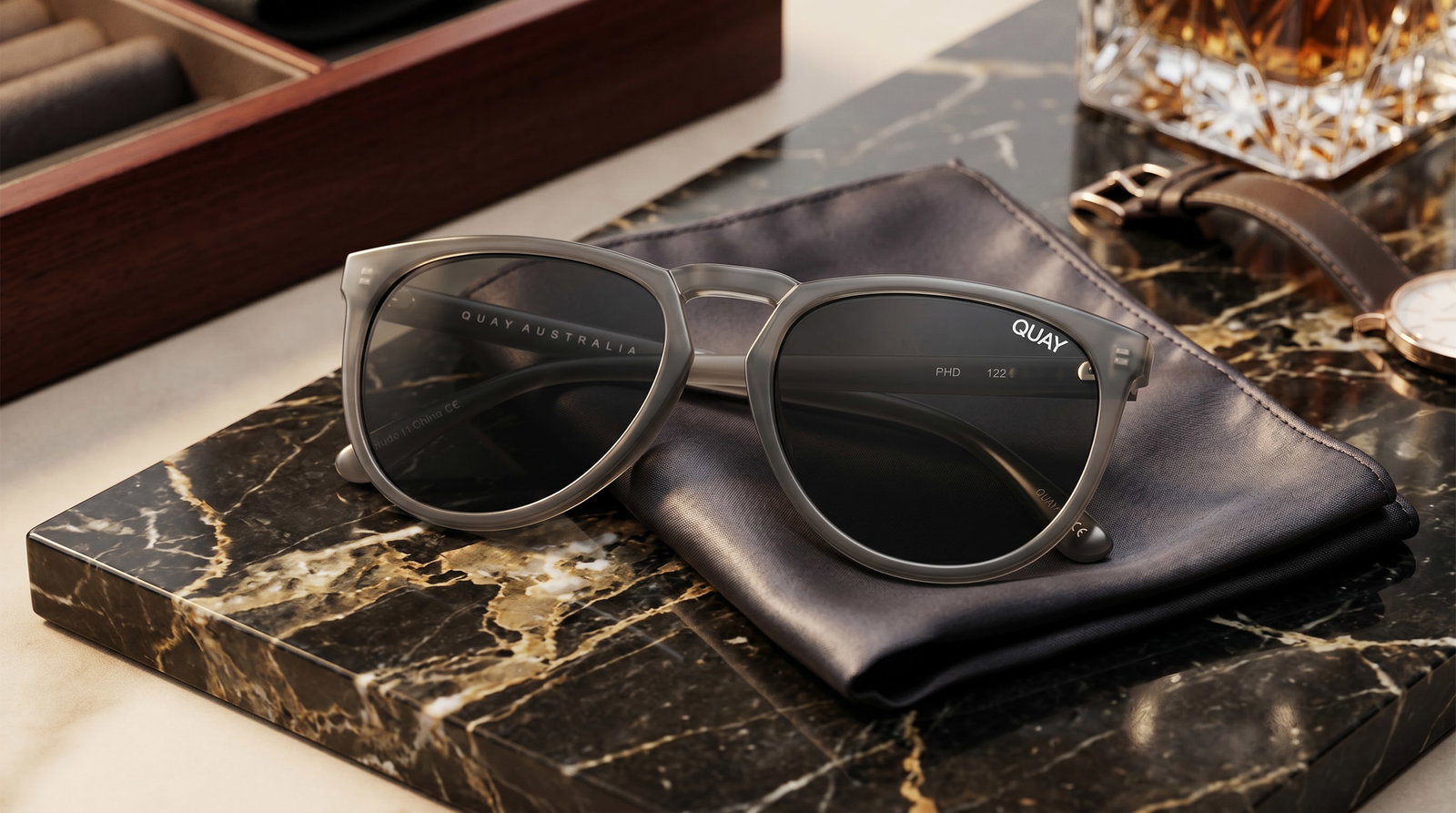 QUAY AUSTRALIA PHD SUNGLASSES IN GREY SMOKE: These sunglasses are the Quay PHD model in Grey Smoke. This design is a modern, oversized take on a classic silhouette, featuring:Translucent Frames: A matte, "grey smoke" finish that allows some ligh