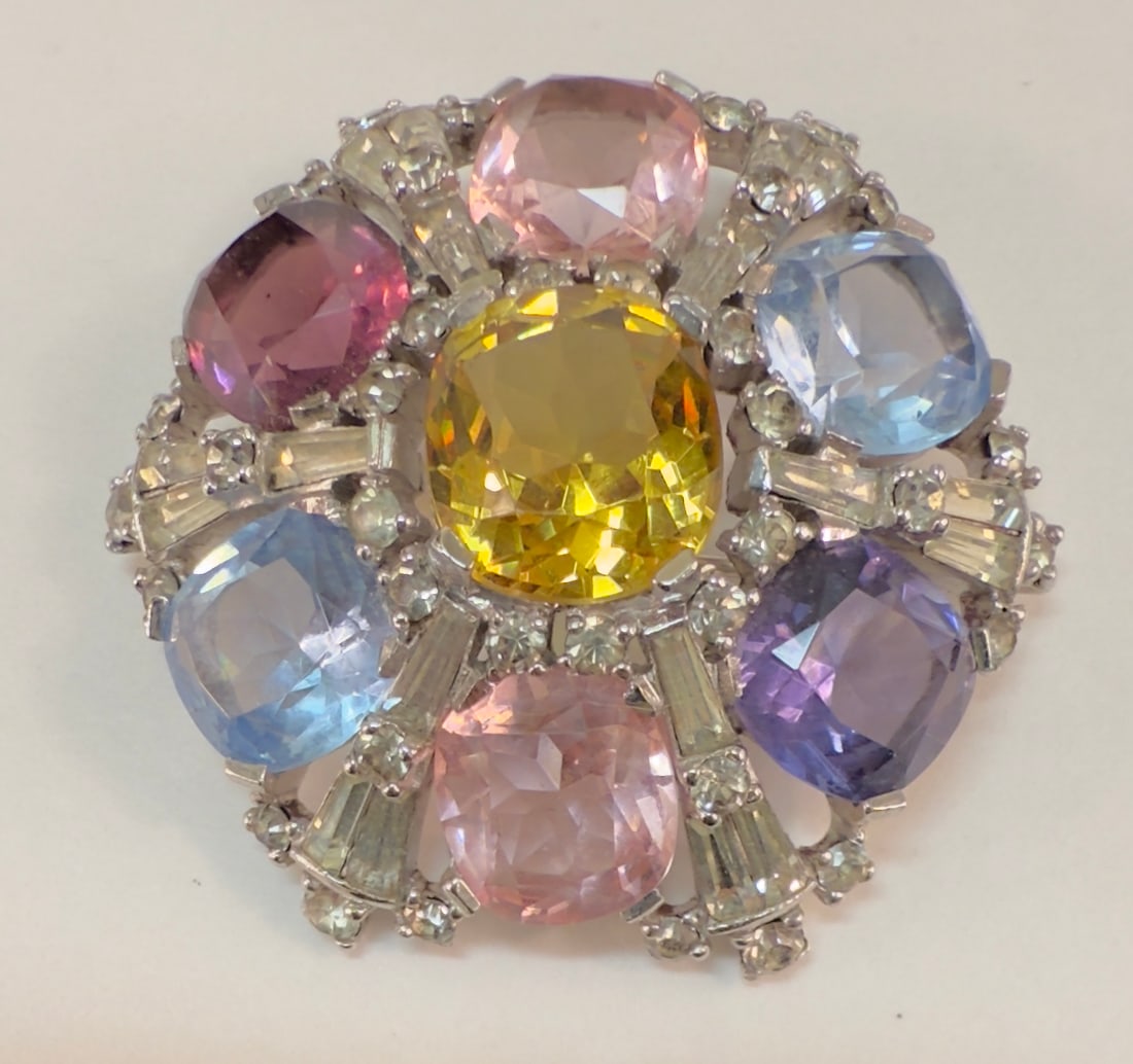 Large Vintage Jomaz Multi Color Stone & Rhinestone Brooch Pin: From an upstate, NY estate collection. Signed Jomaz pin or brooch, with large colorful faceted glass stones and rhinestone starburst surround. Silver tone, barrel clasp on pin. Measures approx 1.85" i