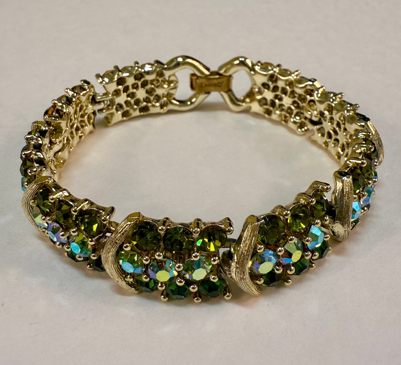 Vintage 1950s-60s Tri-Tone Lisner Green Rhinestone Bracelet: From an upstate, NY estate collection. Signed Lisner on clasp. Silver tone bracelet, with gold tone fold over clasp. Tri-tone green aurora borealis rhinestones. Measures approx 7.25" long by approx .5