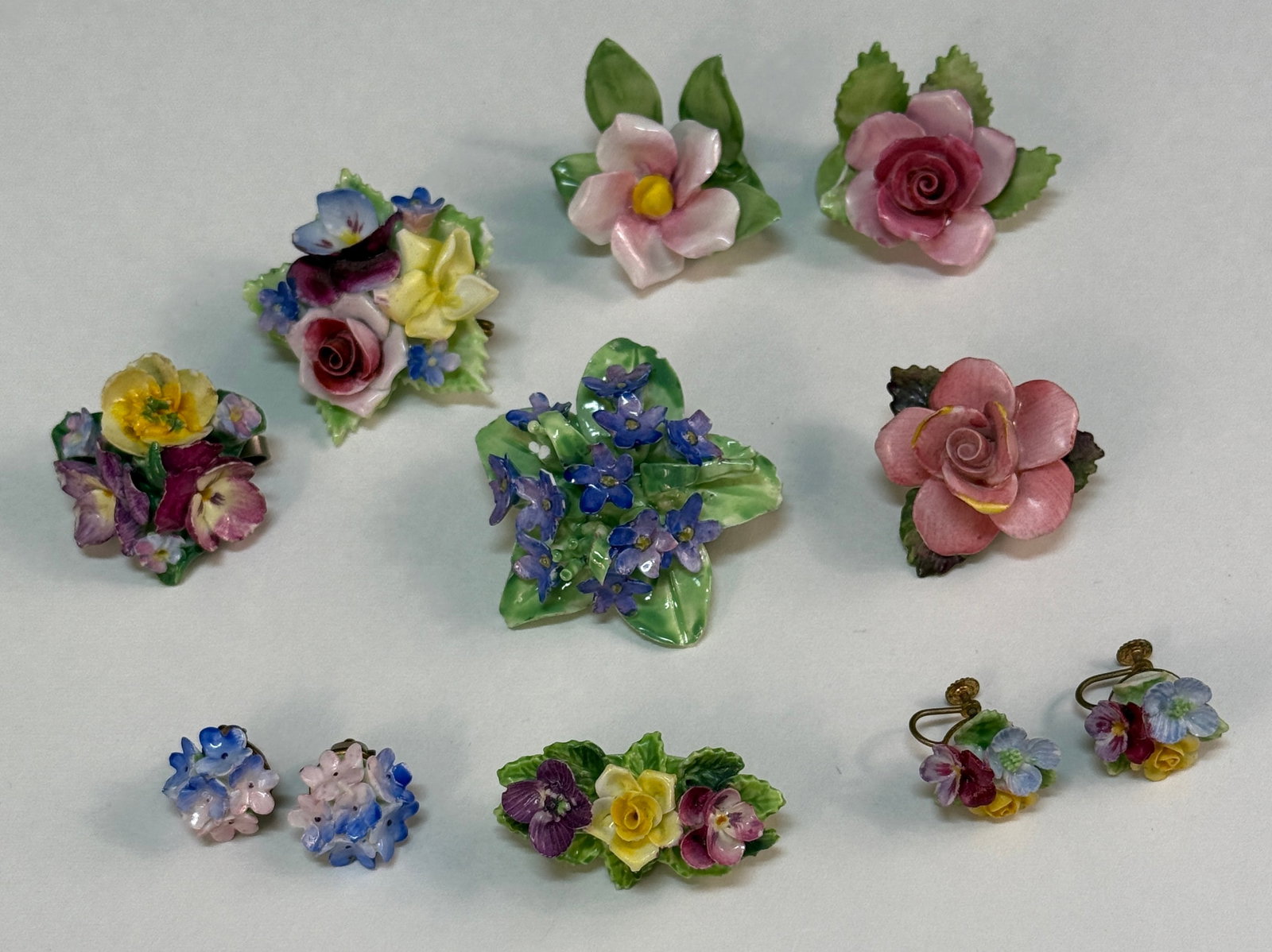 Group of Nine Staffordshire Porcelain Jewelry Pieces / Place Card Holders: From an upstate, NY estate collection. Group of nine pieces of Staffordshire porcelain jewelry and accessories. Five pins / brooches (some marked), two place card holders (both marked Adderly), and tw