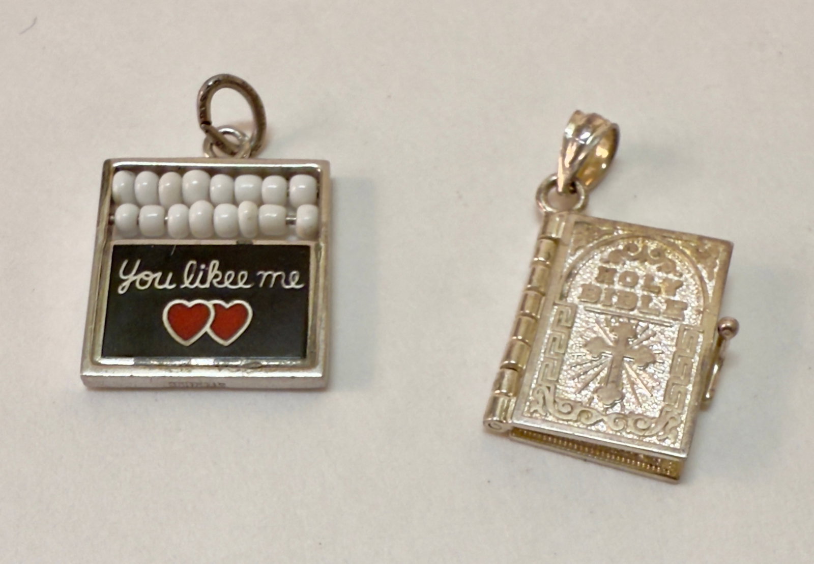 Group of Two Vintage Sterling Silver Charm Charms - Holy Bible with Pages & Abacus: From an upstate, NY estate collection. Group of two vintage sterling silver charms including a mechanical Holy Bible on hinges with two pages, and an enameled abacus with white beads which says, "I Li