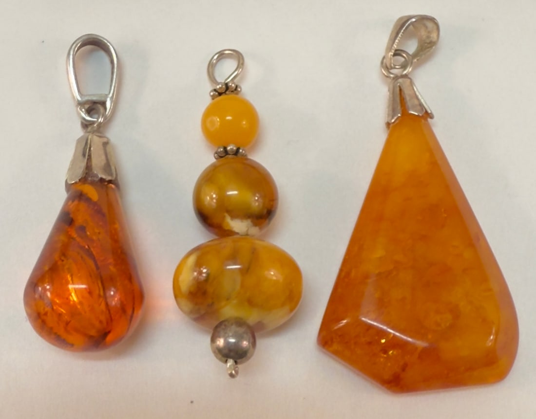 Group of Three Sterling Silver & Various Amber Stone Pendants: From an upstate, NY estate collection. Group of three sterling silver and amber stone pendants. All are tested sterling. Group weighs a total of 9.6 grams.
