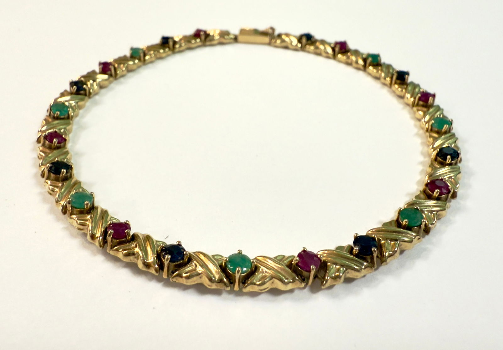 14K Yellow Gold Link Bracelet With Rubies, Sapphires, Emeralds: From an upstate, NY estate collection. Tested and marked 14K yellow gold link bracelet, set with eight rubies, eight blue sapphires, and eight emeralds. clasp. Measures just under " long by just over
