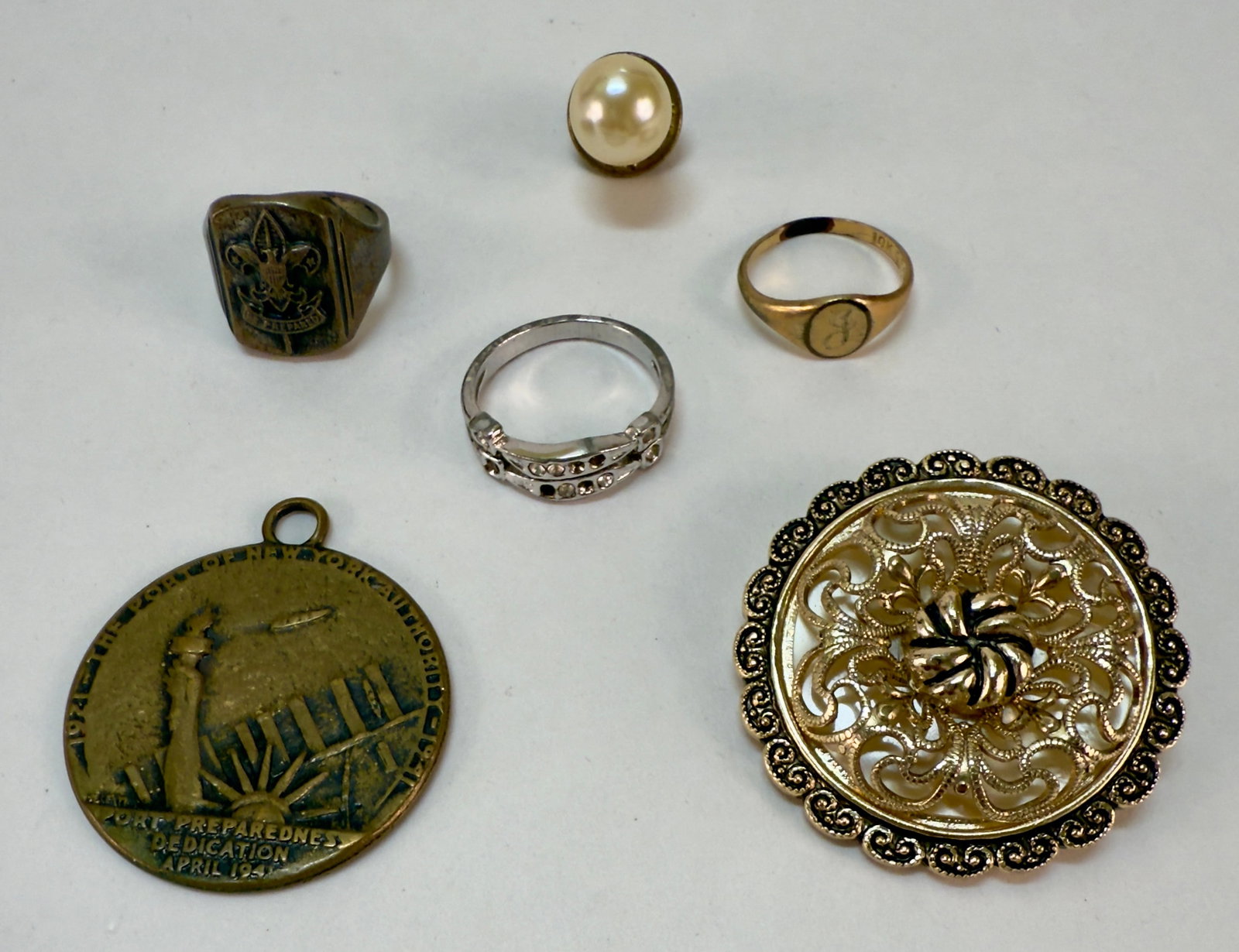 Group Antique & Vintage Costume Jewelry 1941 World's Fair, Boy Scout: From an upstate, NY collection. Six-piece group of various costume jewelry pieces including three rings (including a Boy Scout ring), a faux pearl tie tack, a scarf clip and a 1941 World's Fair pendan