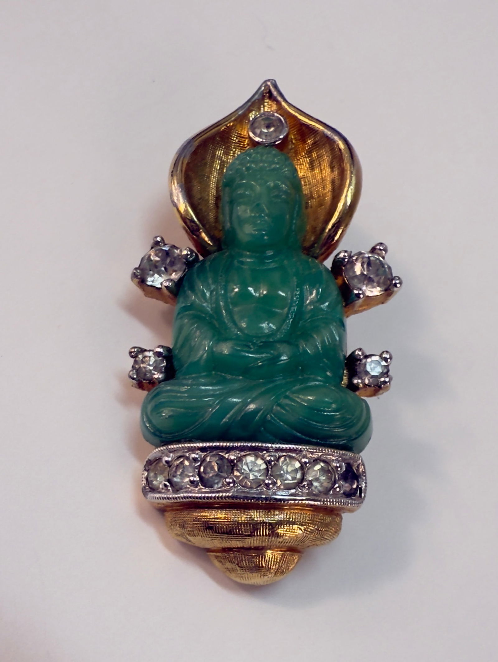 Rare Unmarked Jomaz by Joseph Mazer Asian Buddha Peking Glass Pin Brooch: From an upstate, NY estate. Hard to find unsigned Jomaz by Joseph Mazer pin of brooch in gold tone, rhinestones, and with green Peking glass Buddha. Measures approx 1.75" long.