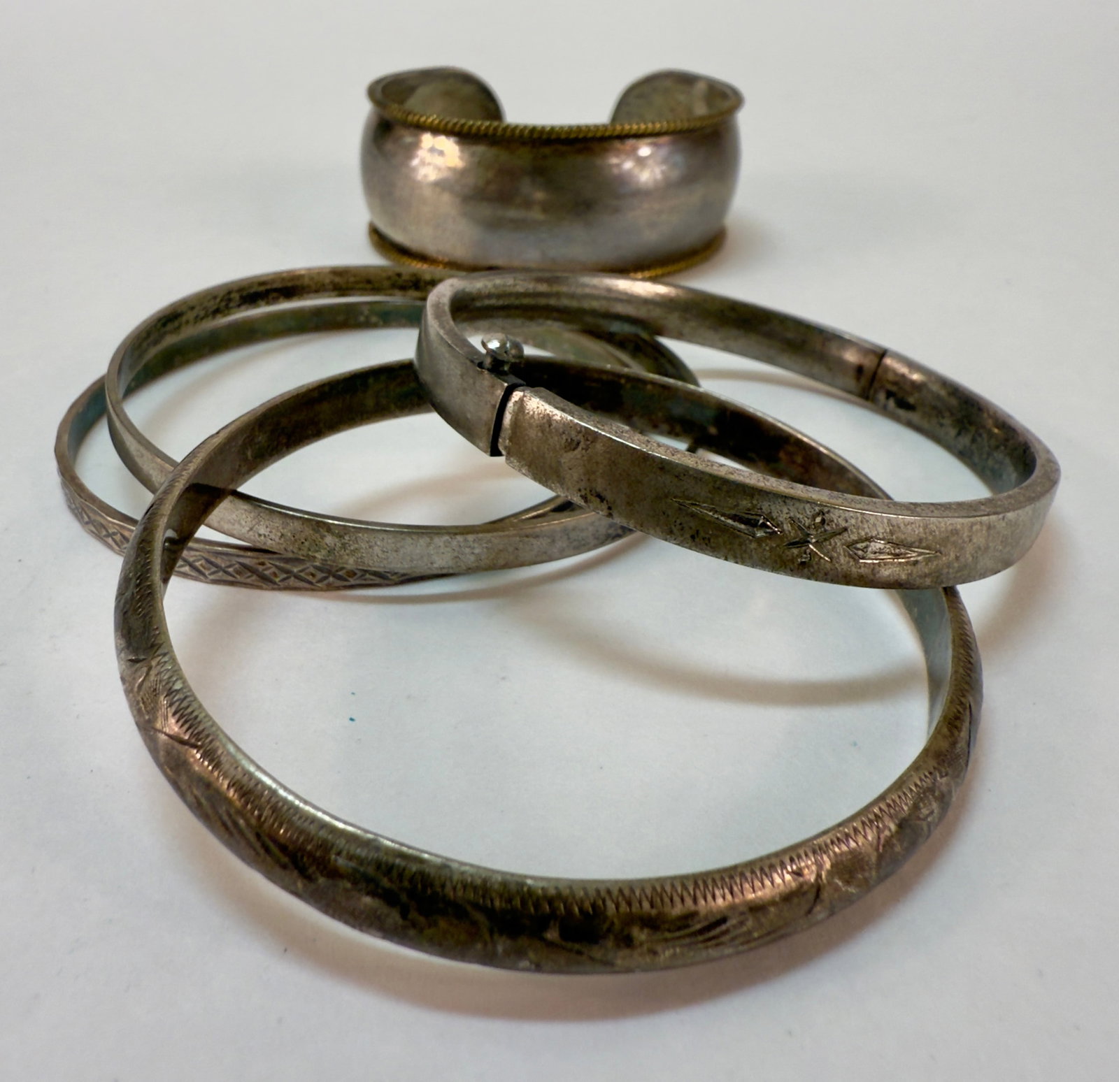 Group of Five Vintage Sterling Silver Bracelets Cuff Bangles: From an upstate, NY estate. Group of four sterling silver bangle bracelets with various patterns and designs, and one open cuff bracelet with gold plate braided edge and Taxco markings. One bangle has