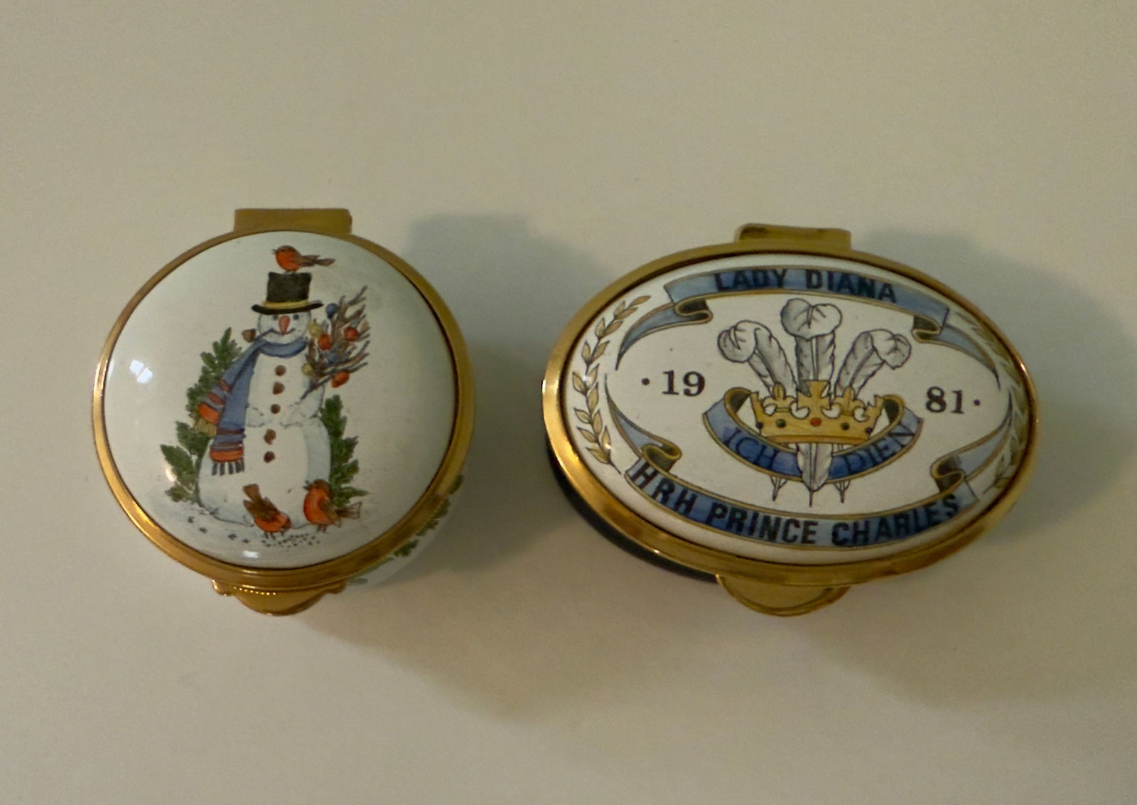 Pair of Porcelain Pill Boxes Enamel Crumles & Co HRH Charles & Diana Staffordshire Enamels England: From an upstate, NY estate. Pair of limited edition porcelain enameled pill boxes, made by Crumles & Co and Staffordshire Enamels, England. Hand painted lids, one with a Christmas snowman and one for