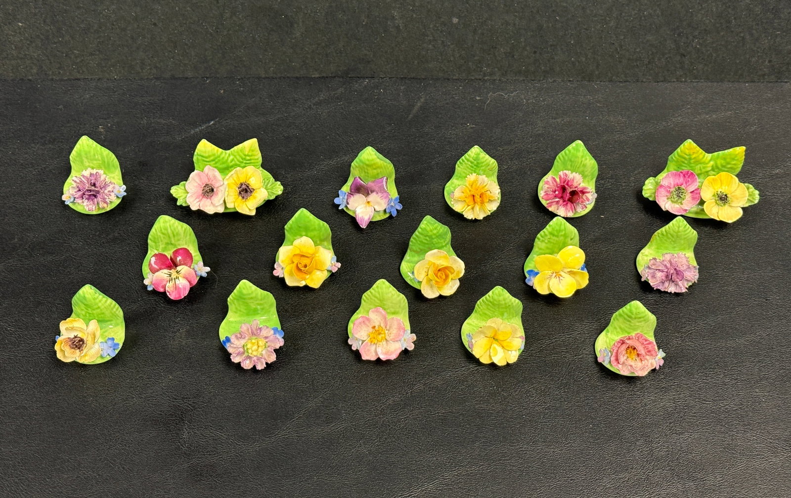 Set of 16 Coalport Porcelain Flower Place Card Holders: From an upstate, NY estate. Group of sixteen Coalport England flower porcelain place card holders. A few have tiny chips to flower petals. Larger ones measure approx 2" x 1.25" x 1". Please see