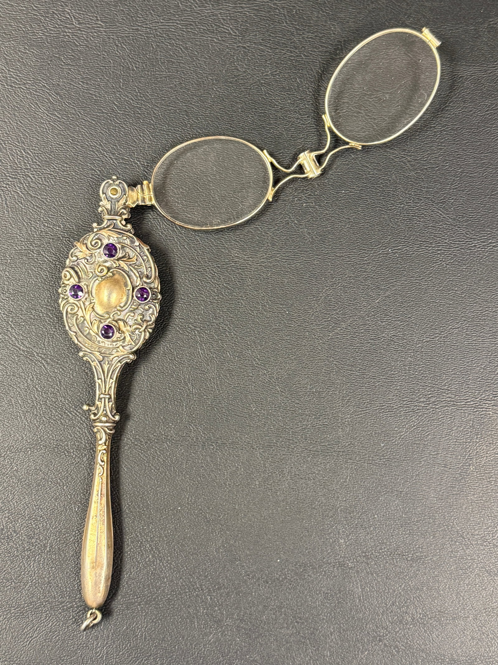 Art Nouveau Repousse Silver with Gilt Amethyst Lorgnette: From an upstate, NY estate. Antique Art Nouveau repousse sterling silver lorgnette with amethysts. Appears to need repair. Opens with a spring clasp, but looks like it was forced to open in the wrong