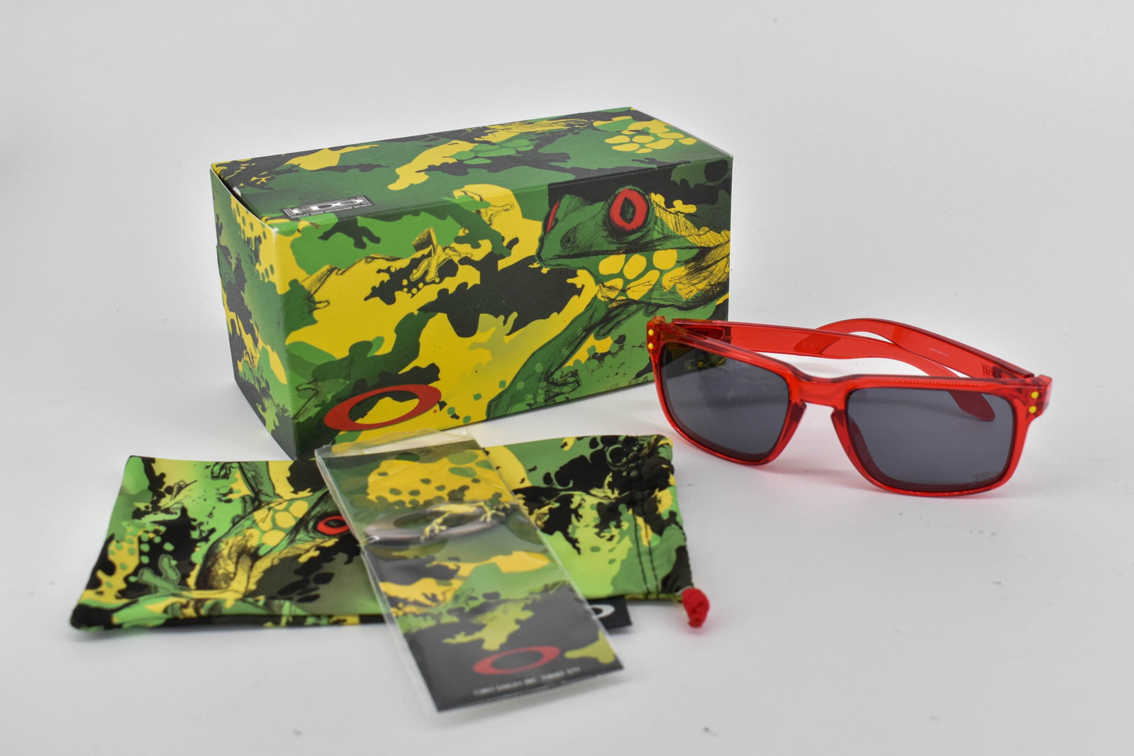 Oakley Jupiter Camo Holbrook Sunglasses, Crystal Red/Grey: Oakley Jupiter Camo Holbrook sunglasses, with crystal red translucent frame and grey lenses. Model 009102-13 55 18. In original box. Comes with soft case and Oakley frog pin.
