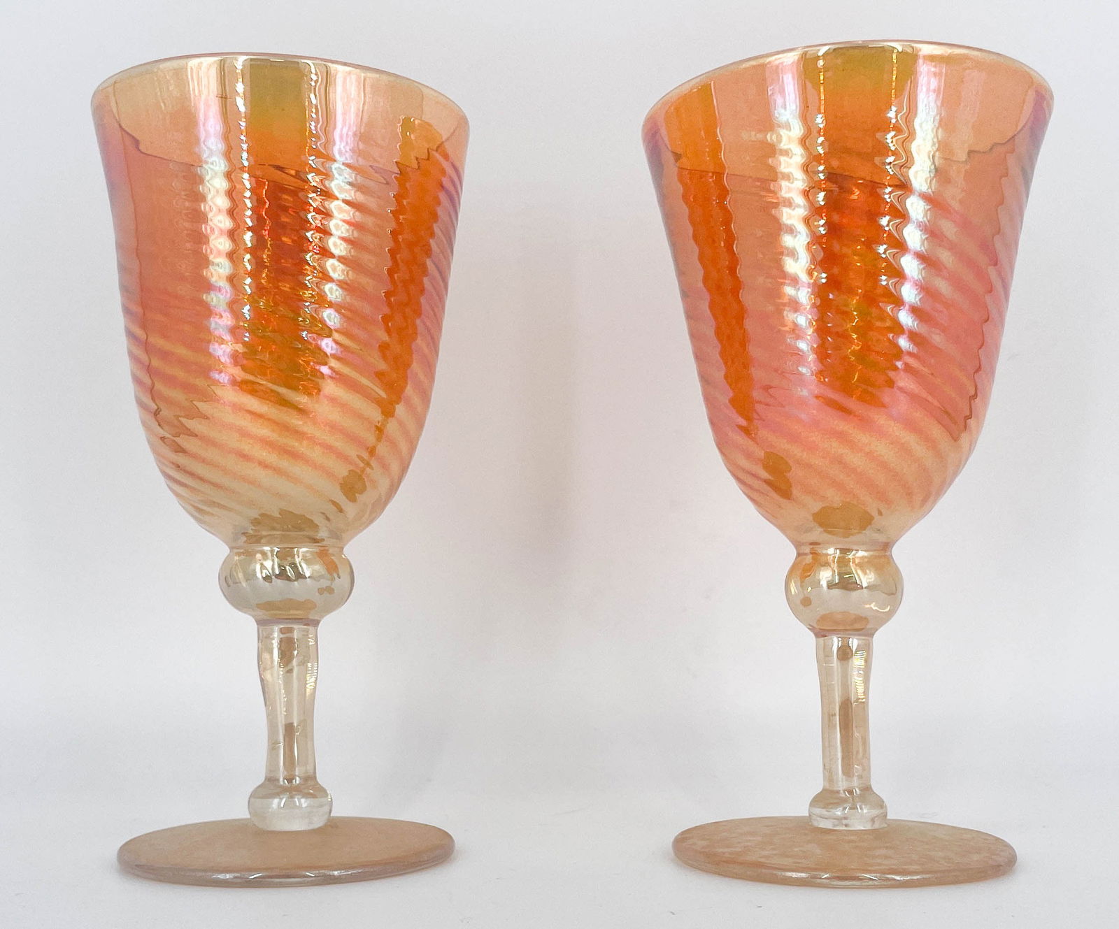 Pair of Strini Hand-Blown Wine Glasses: Pair of Rick Strini iridescent hand-blown art glass wine water goblets. Faintly etched signature along the underside of both glasses.