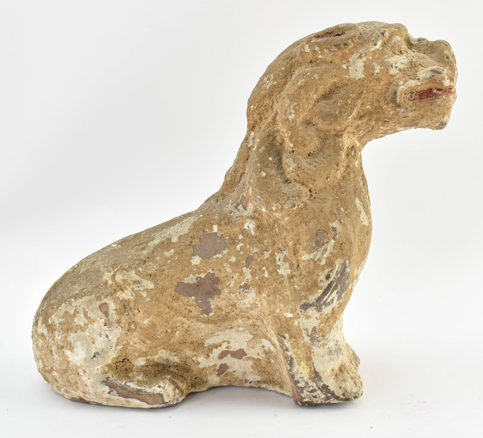Chinese Han Dynasty Pottery Beast Statuette: Early Chinese Han dynasty pottery beast, possibly a mythical beast or foo dog. Traces of paint remain, especially red in the mouth and ears and yellow near the legs.