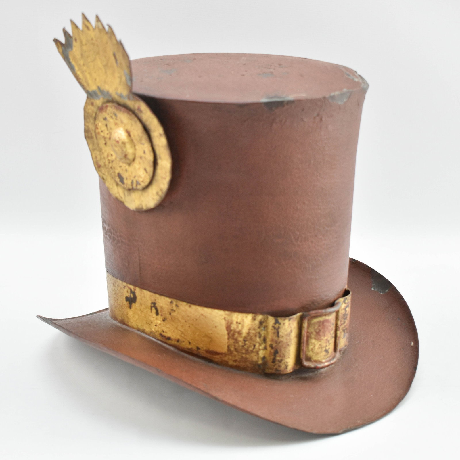 Vintage Metal Top Hat: Maroon hat sculpture made from metal, likely tin, with a medal-shaped attachment and a faux buckle. Perfect for adding antique flair to your home decor!