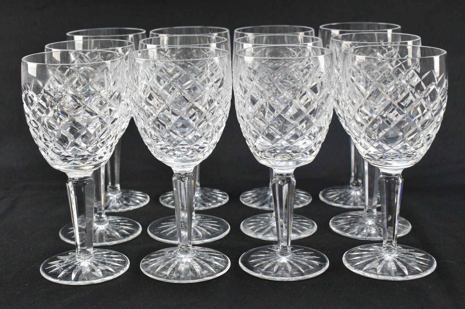 12 Waterford Crystal Goblets: 12 wine glasses in a diamond-cut pattern made by Irish luxury crystal manufacturer Waterford. Each features the Waterford stamp on the underside.