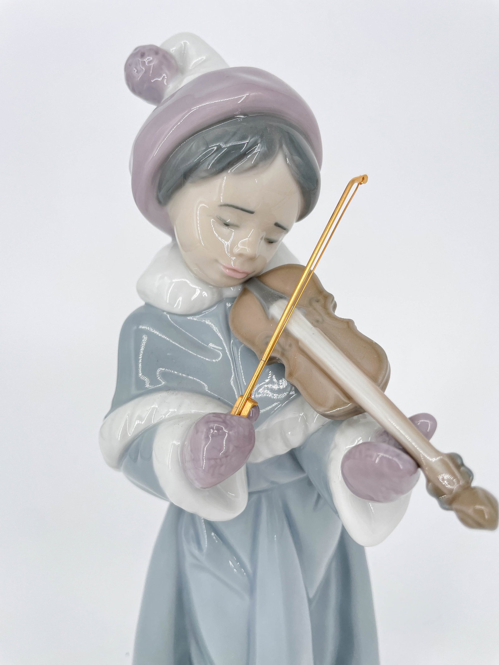 Lladro Spirit of Christmas Girl Porcelain Figure: Lladro "The Spirit of Christmas" porcelain figurine depicting a young girl playing a violin. Marked with Lladro stamp along the underside.