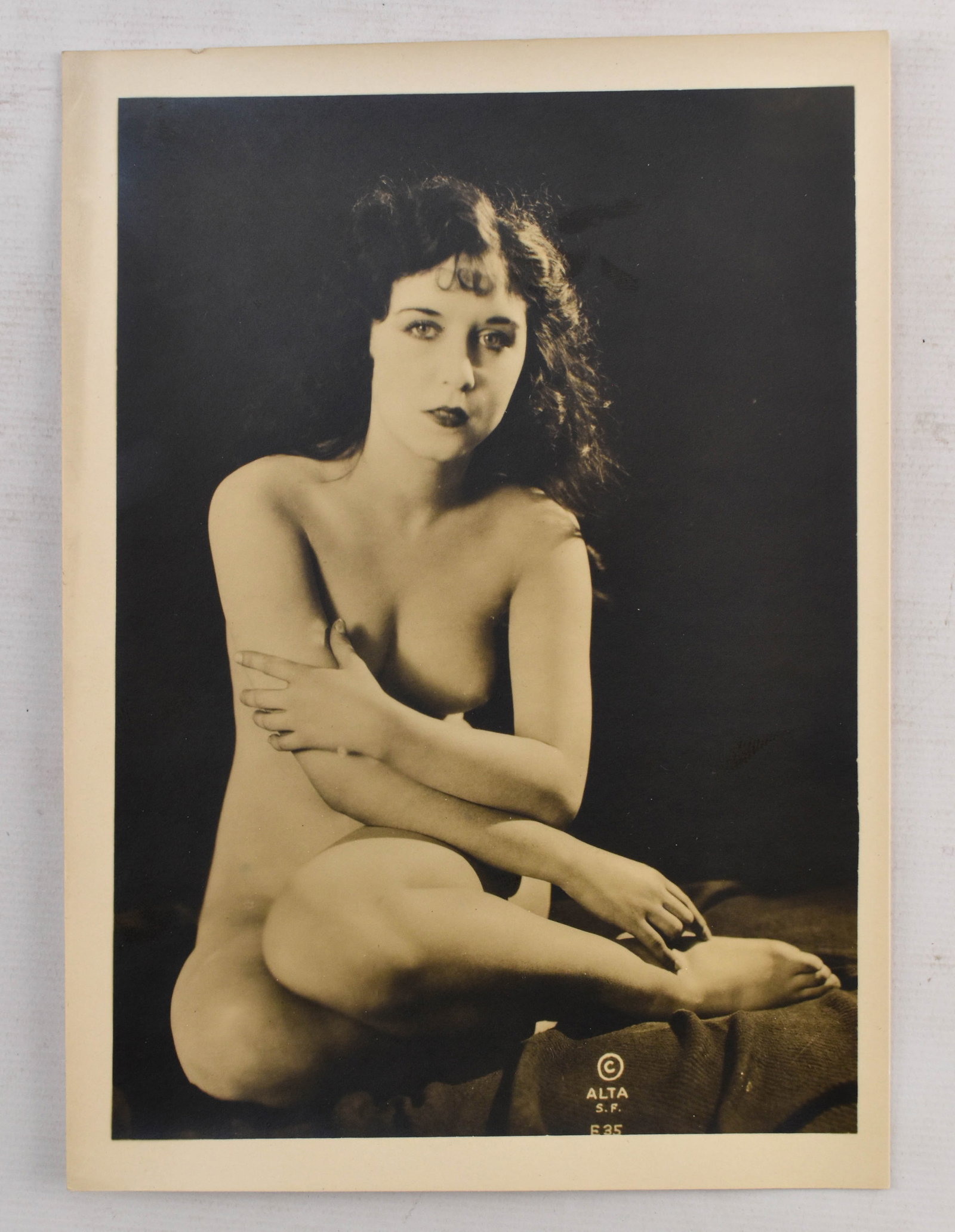Vintage Boudoir Portrait Photo by Alta: 7 x 5 vintage boudoir photograph of a nude woman resting on a bed published by Alta. Copyrighted in the lower right corner. Black and white.