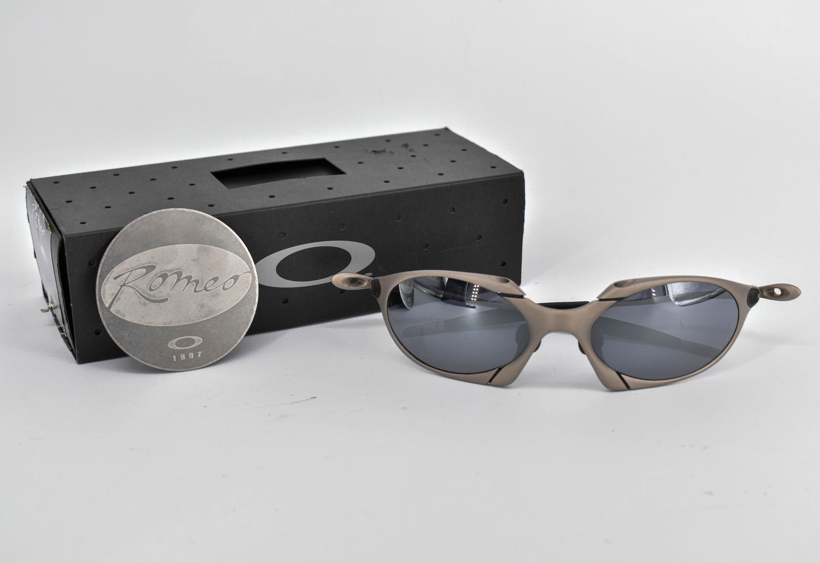 Oakley Romeo 1 X Metal Sunglasses, Grey/Black Iridium: Oakley Romeo X Metal sunglasses with grey metal frame and black iridium lenses. Model 022035. In original box. Comes with soft case and collectible Romeo 1997 coin.