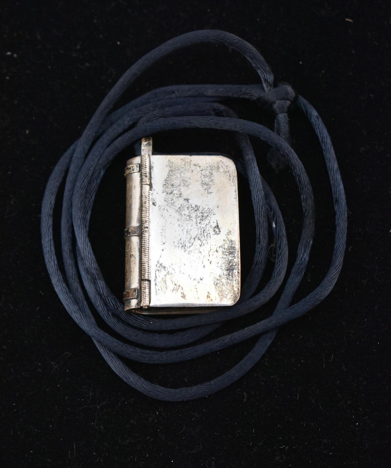 Sterling Silver Mexican Book Locket Pendant: One sterling silver Mexican book box pendant. The pendant opens and is marked along the interior. With a black cord necklace.