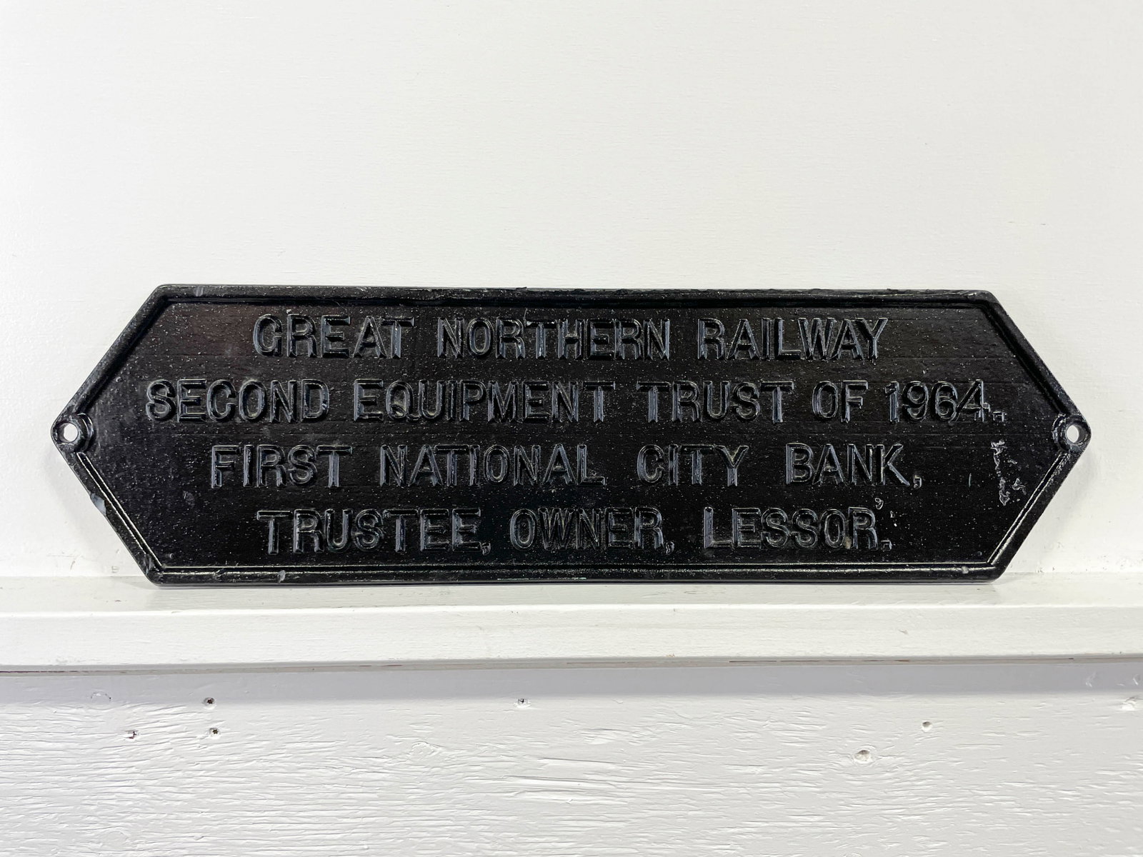Great Northern Railway 1964 Black Cast Metal Plaque: One 1964 cast metal plaque. The front with black enamel paint. Reading "Great Northern Railway Second Equipment Trust of 1964. First National City Bank, Trustee, Owner, Lessor." 9 x 30 x 0.5