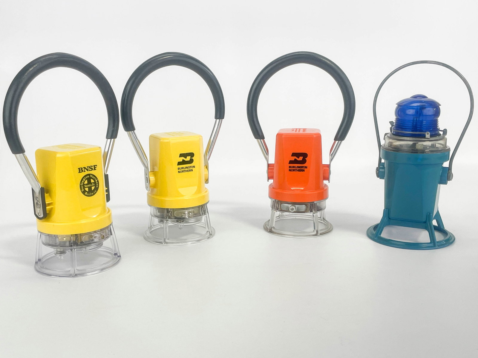 4 Railway Battery Lamps: Group of four railroad battery lamps. Including: one Burlington Northern Starlite model 222 orange lamp; one Burlington Northern Starlite model 292 yellow lamp; one BNSF Railway Starlite model 292 yel