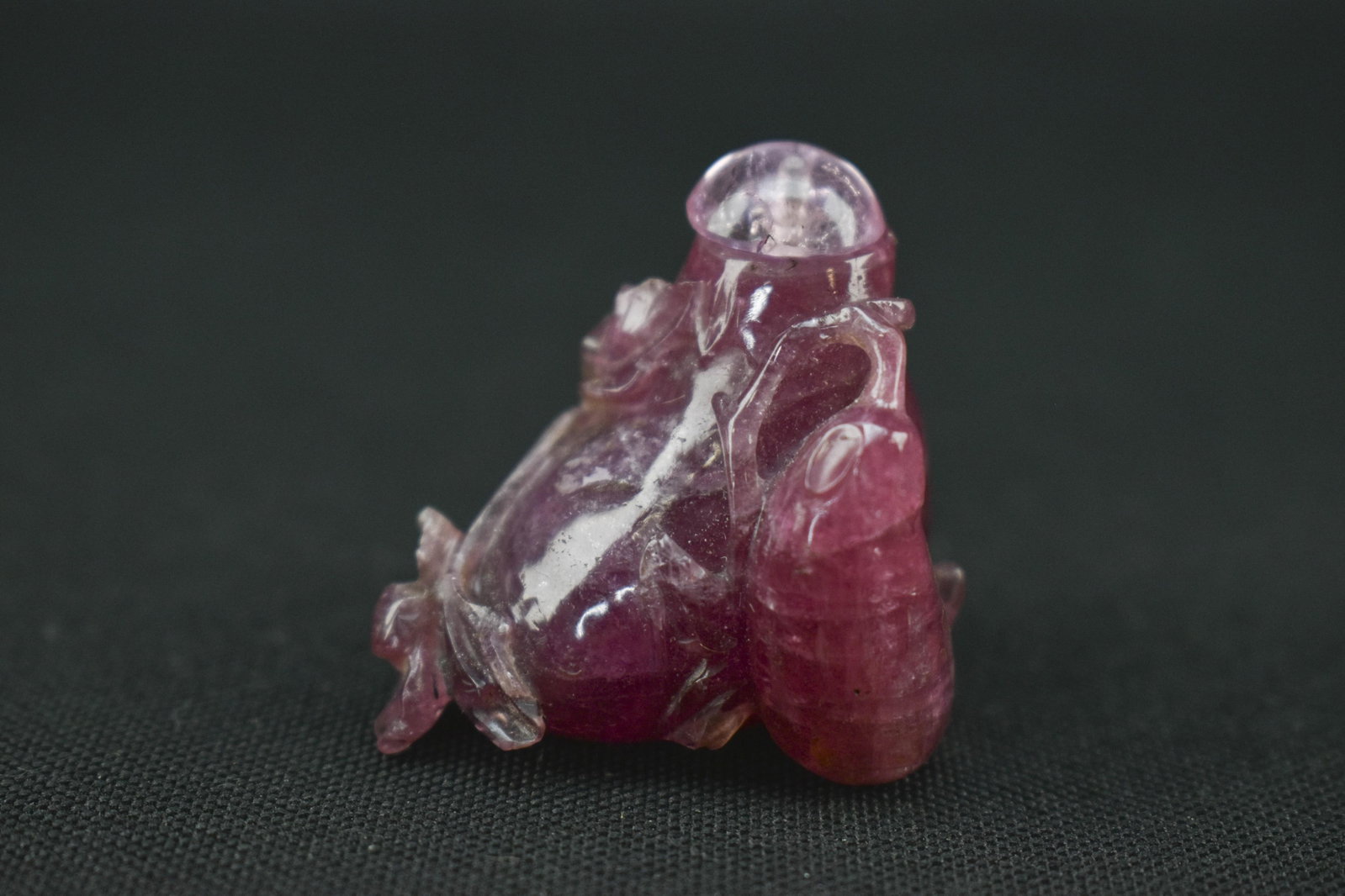 Rubellite Tourmaline Snuff Bottle: 1.25 x 1.25 x 1. Small snuff bottle made from rubellite tourmaline stone in the form of an eggplant or other fruit. 1.25H x 1.25W x 1L