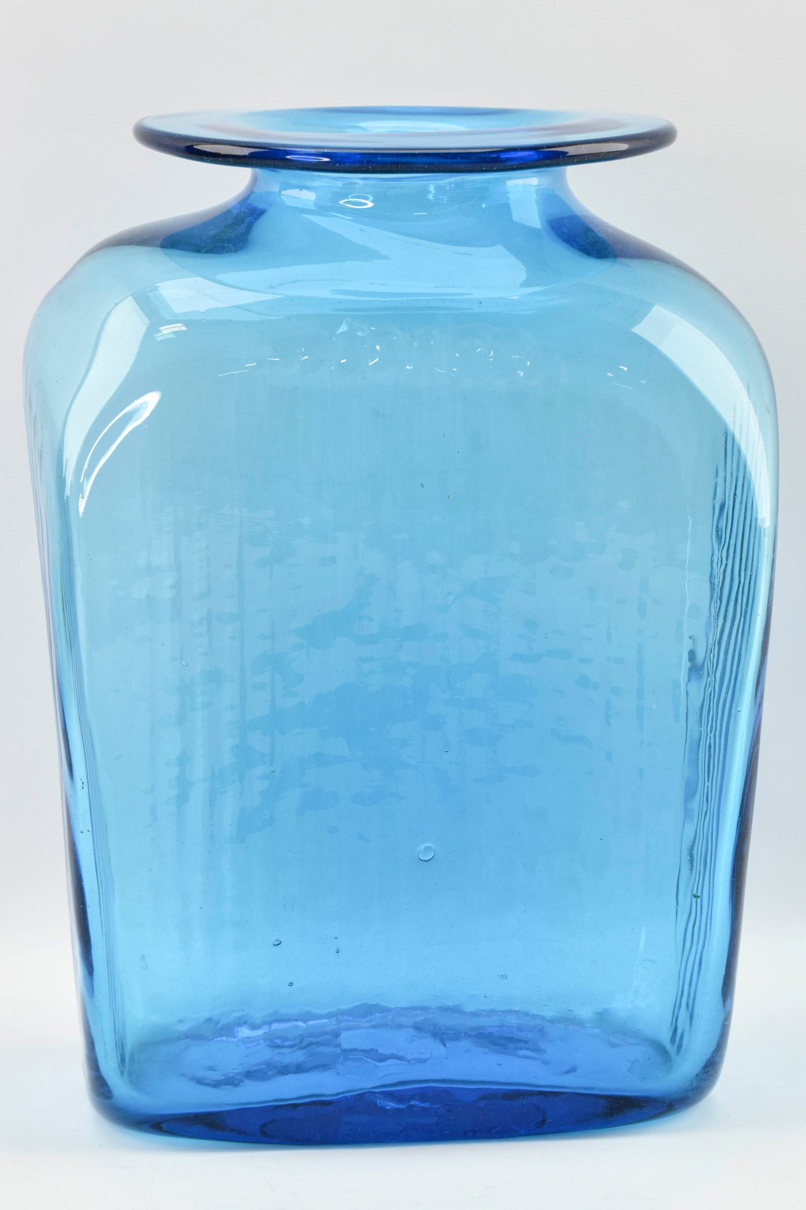 Blenko Large Blue Ribbed Vase: Large vase by Blenko in a bright blue color, likely either offically Blenko's azure or turquoise color. Vase is slightly asymmetrical and features a ribbed design around the body. 11.5"H x 8"