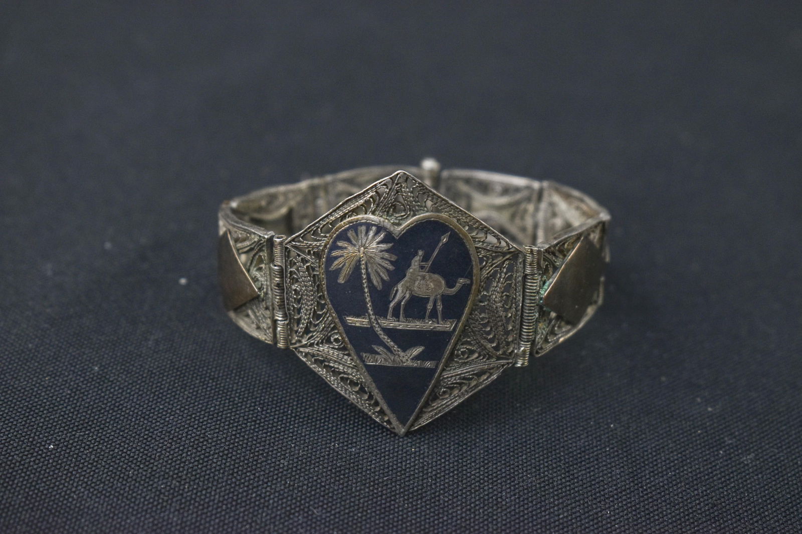 1945 Iran Silver Filigree Niello Bracelet: 6.5 L x 1.5 H. Silver filigree and niello bracelet marked Iran 1945 featuring a camel-mounted solider. Tested as silver in acid test - likely 800 or similar.