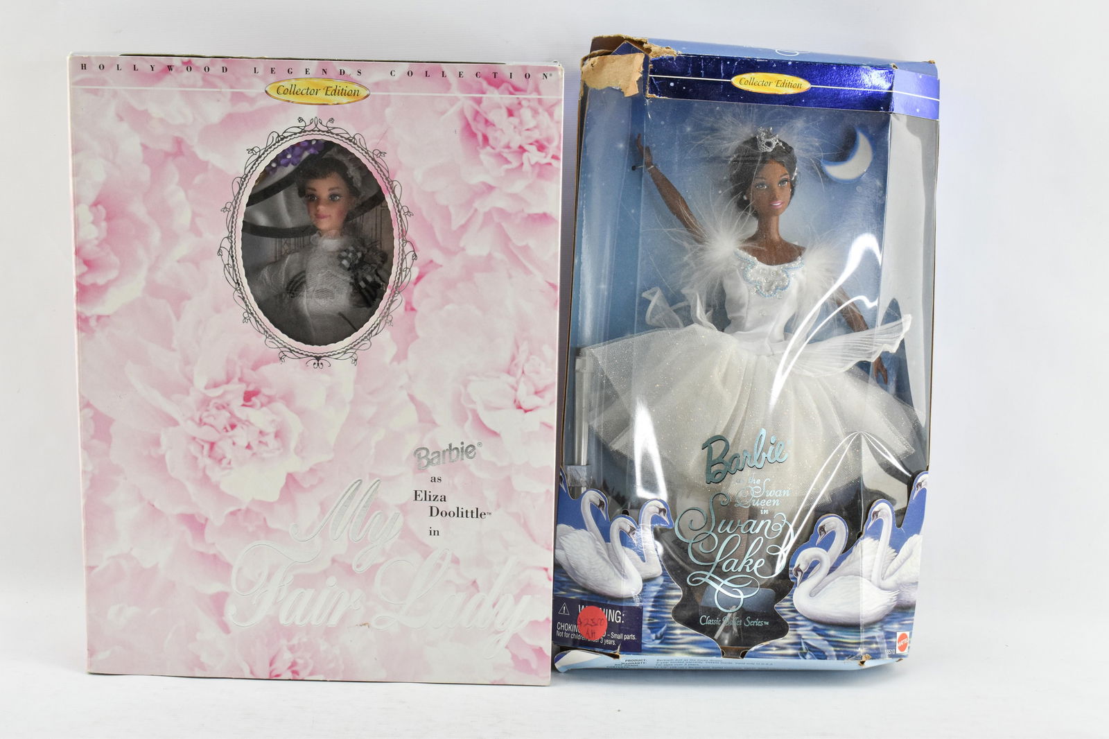2 Barbies - Eliza Doolittle in My Fair Lady & the Swan Queen in Swan Lake: 2 Barbies in unopened packaging including the Hollywood Legends Collection Barbie as Eliza Doolittle in My Fair Lady and Barbie as the Swan Queen in Swan Lake.14 x 10.5 x 3.5