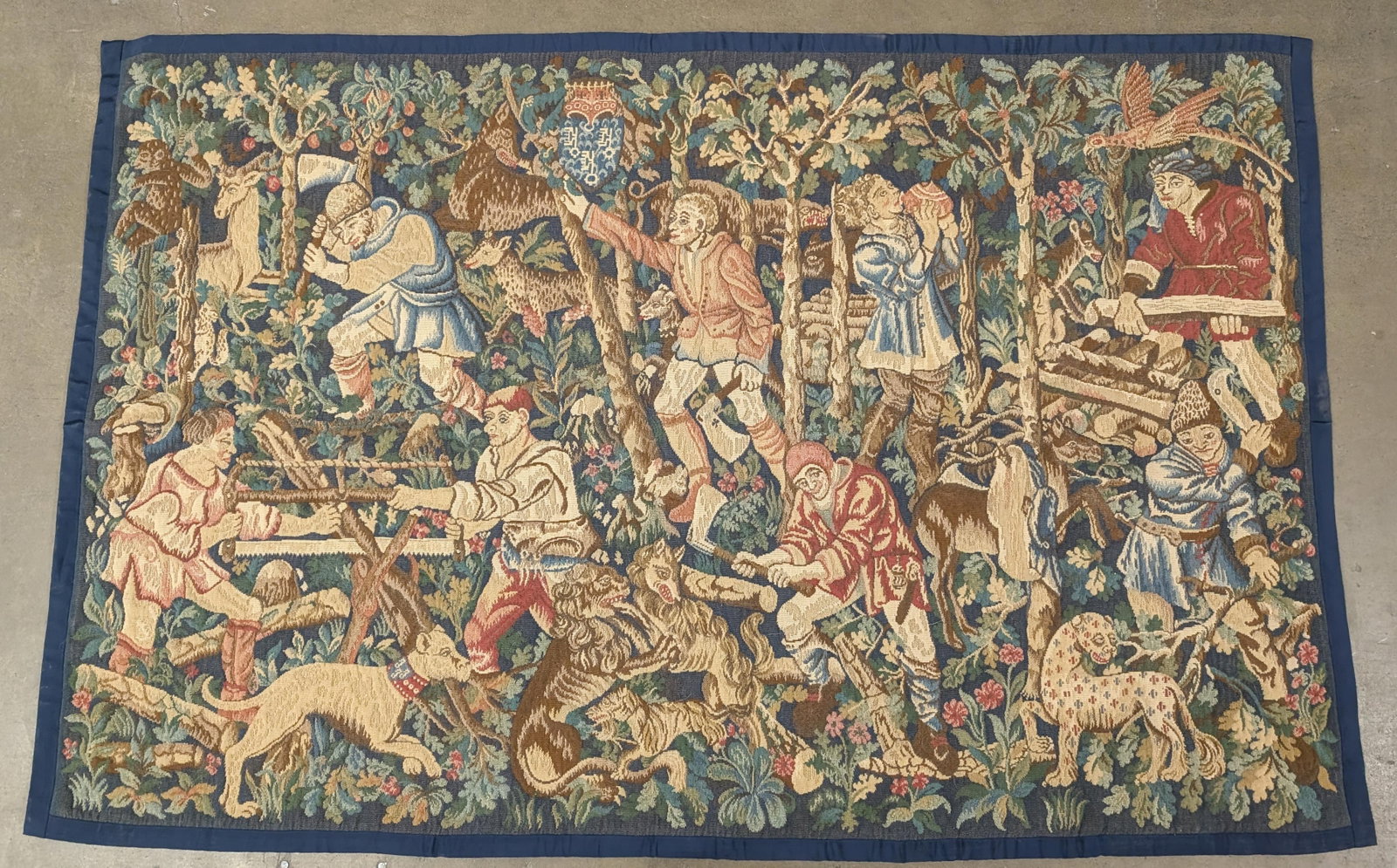 "The Woodcutters" 4' x 7' Tapestry: 20th century Tournai style tapestry depicting woodcutters working the forest among tress and animals. 52"H x 81"W