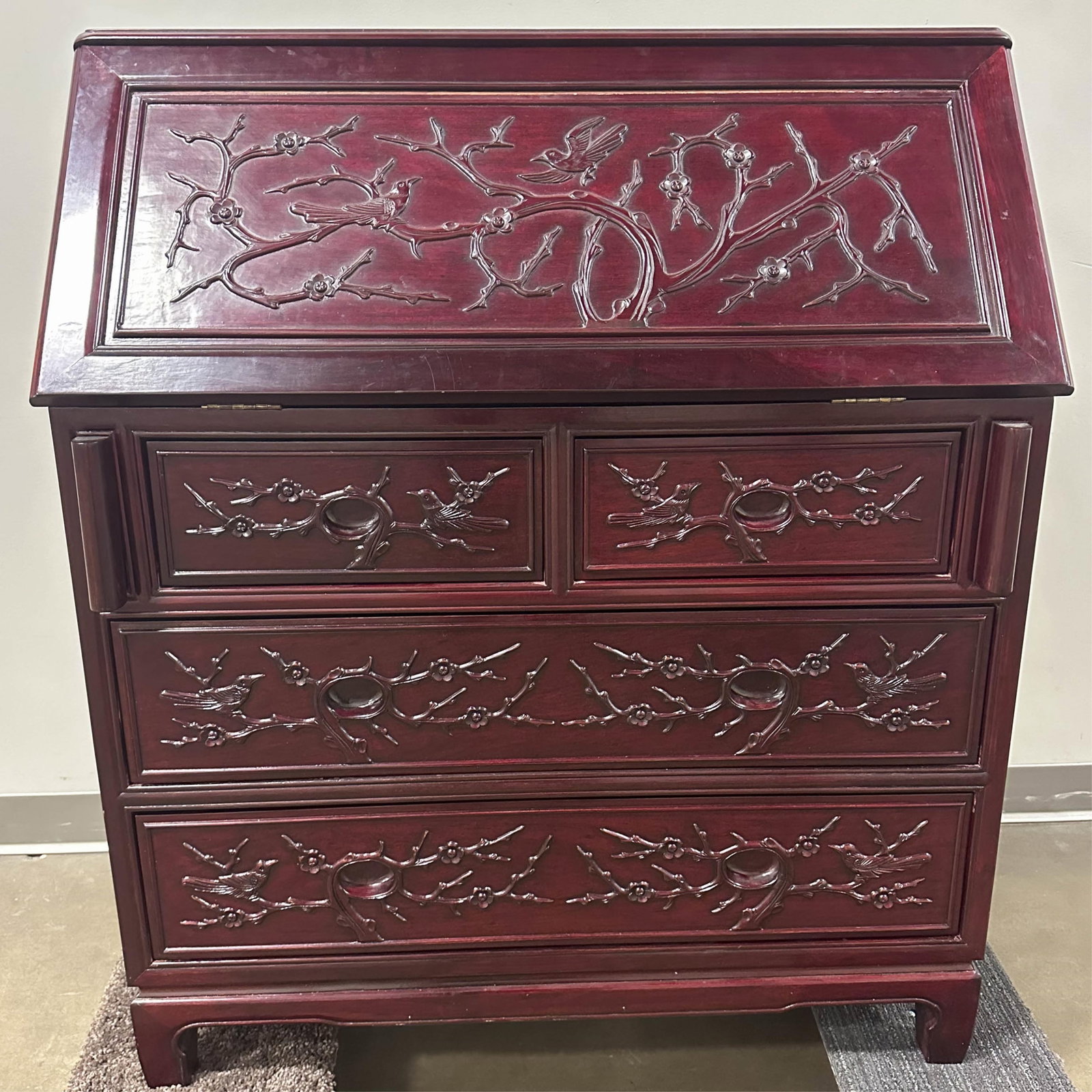 Chinese Rosewood Secretary Desk: Chinese style rosewood or similar secretary desk with stunning branch and bird carved details in relief throughout. Slant top compartment provides much storage space as well as two smaller lower and t