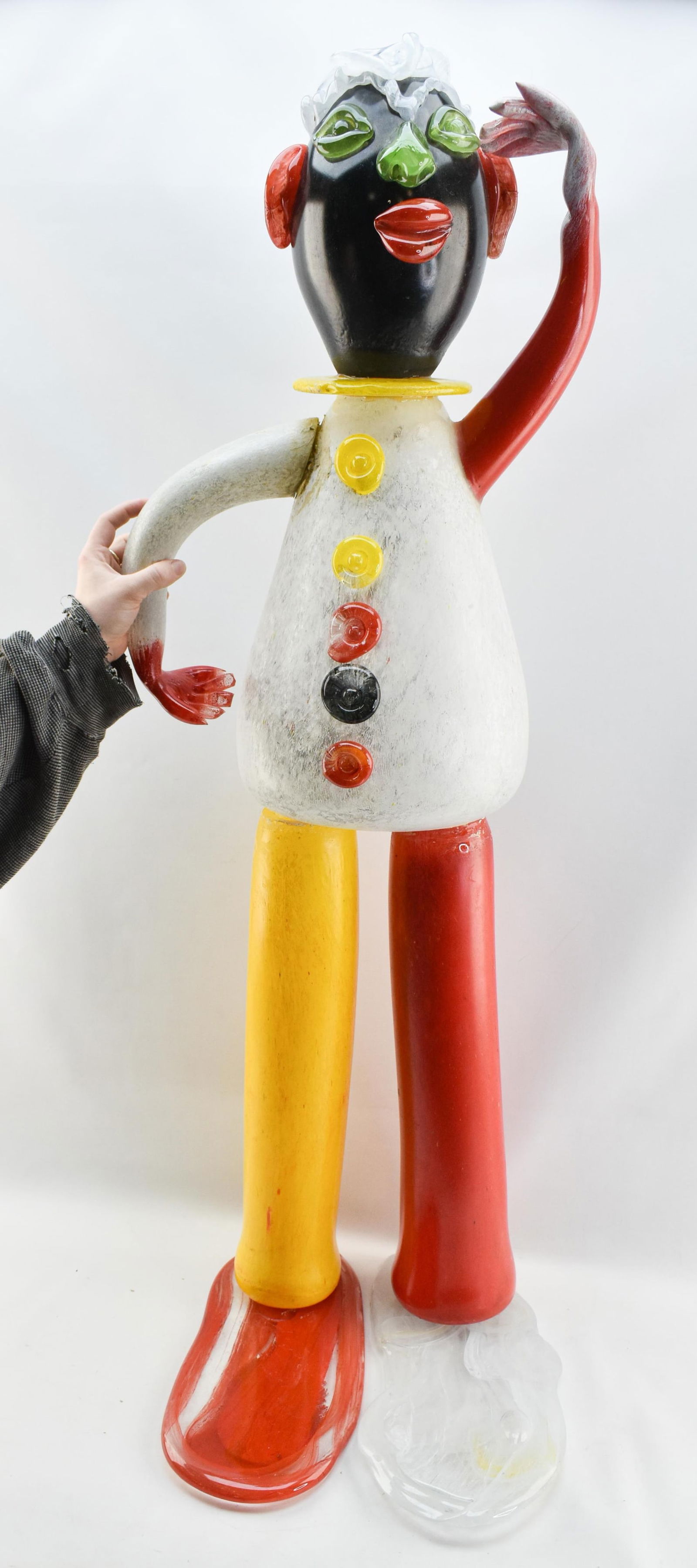 20th c. Jean-Claude Novaro Glass Clown Sculpture: Jean-Claude Novaro (French, 1943-2015). Polychrome and glass sculpture depicting a standing clown with an arm raised, looking into the distance, 20th century.Item is currently in 6 pieces - torso/head