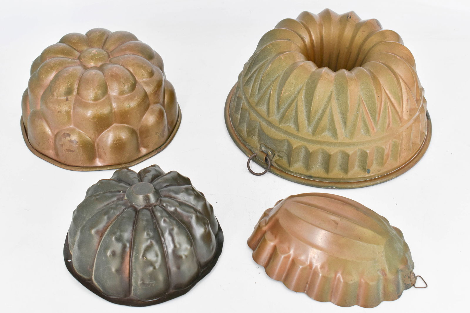 4 Assorted Copper and Brass Jelly Molds: 4 copper and brass jelly/cake molds in a variety of shapes and styles.Largest: 4 1/2"H x 9 1/4"Dia