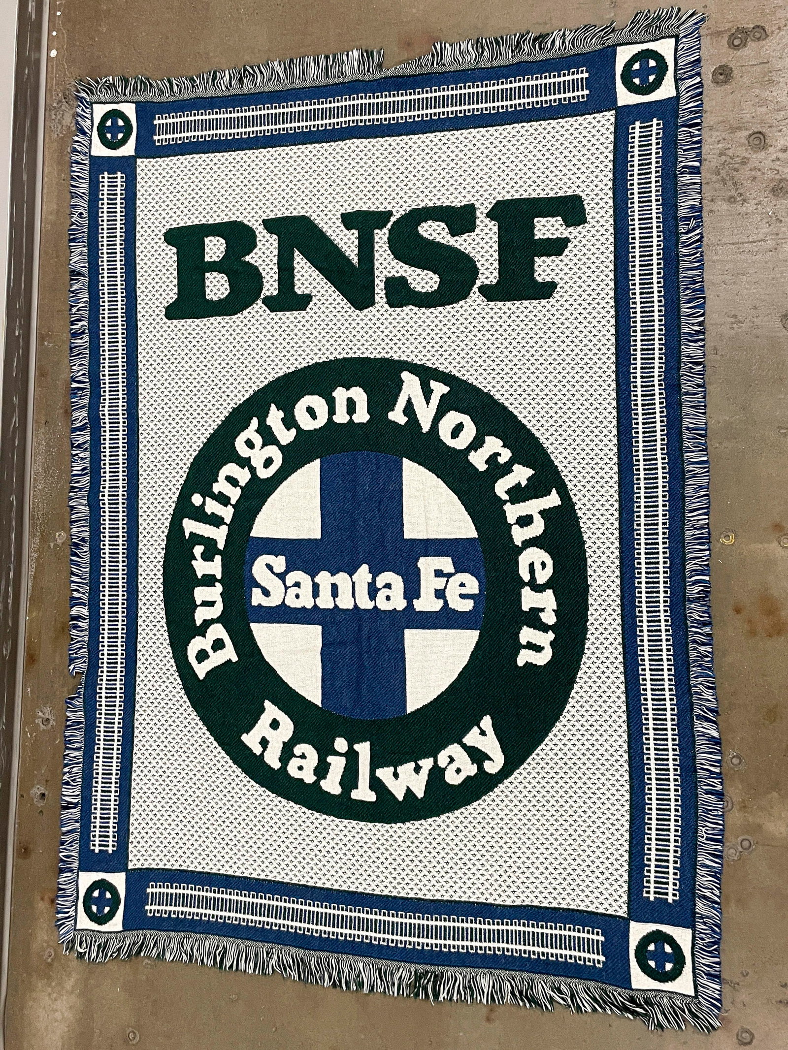 Burlington Northern Santa Fe Railway Logo Blanket: One Burlington Northern Santa Fe Railway tapestry style woven throw blanket with the BNSF logo. In blue, green, and white. 49 x 71 x